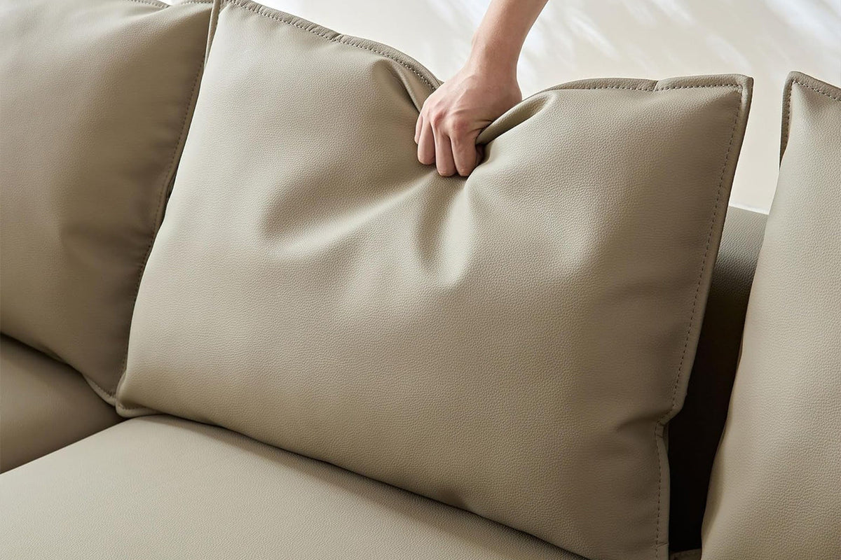 Braunes Ecksofa Venedik links von Hanah Home aus glattem Kunstleder mit Kunststoffbeinen und sieben mitgelieferten Kissen im Wohnbereich.