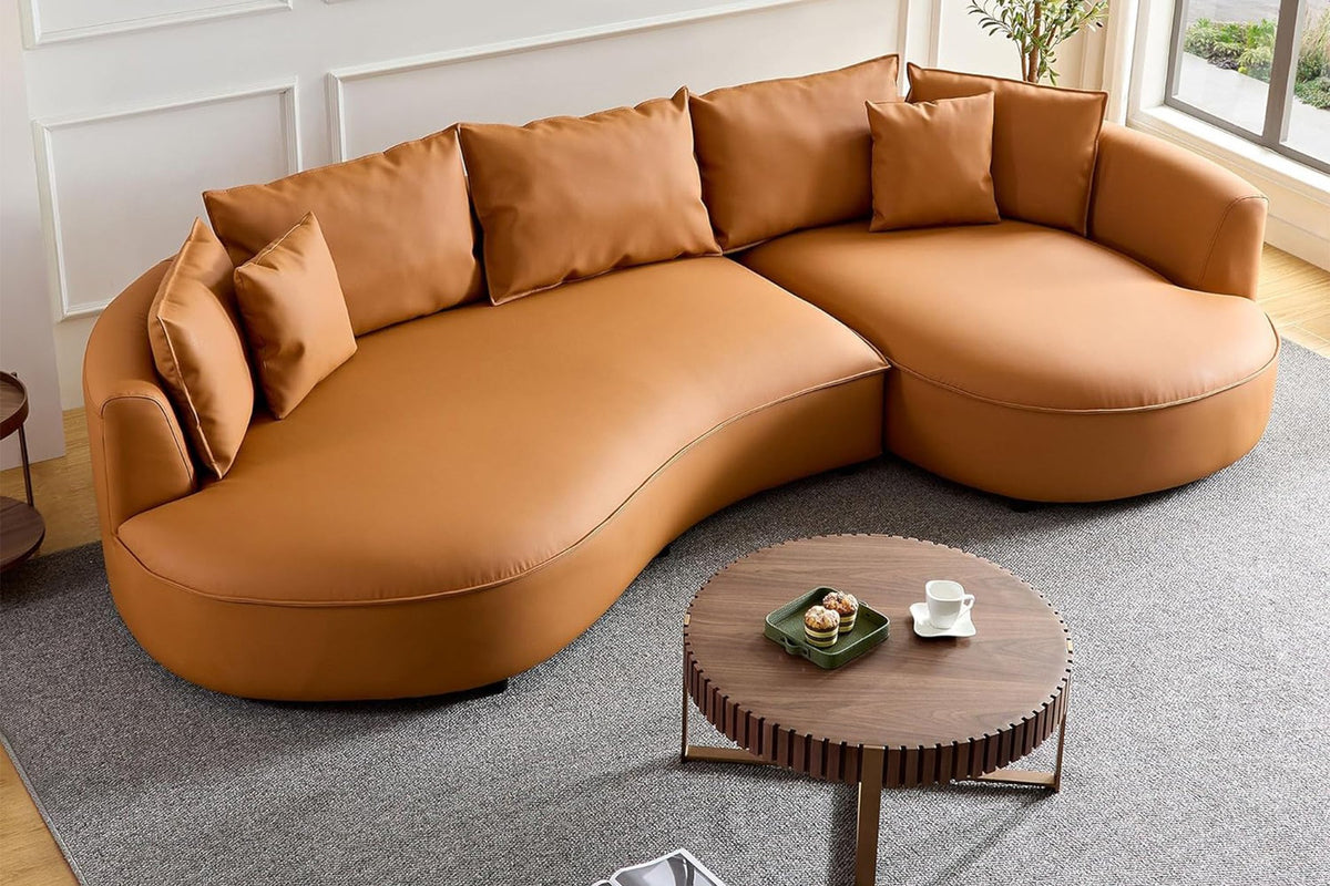 Oranges Ecksofa Venedik von Hanah Home mit glattem Kunstlederbezug, Holzgestell, Kunststoffbeinen und sieben losen Kissen im Wohnraum