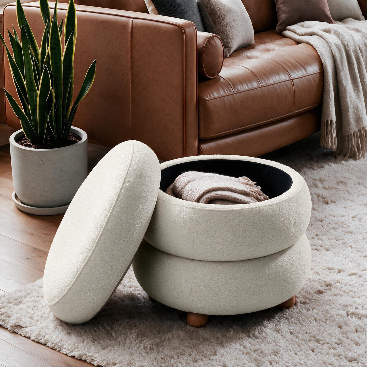Runder Pouf in Off-White von Hanah Home mit gestricktem Polyesterbezug, Holz-Kugelfüssen und sichtbarem Stauraumfach im Innenraum.