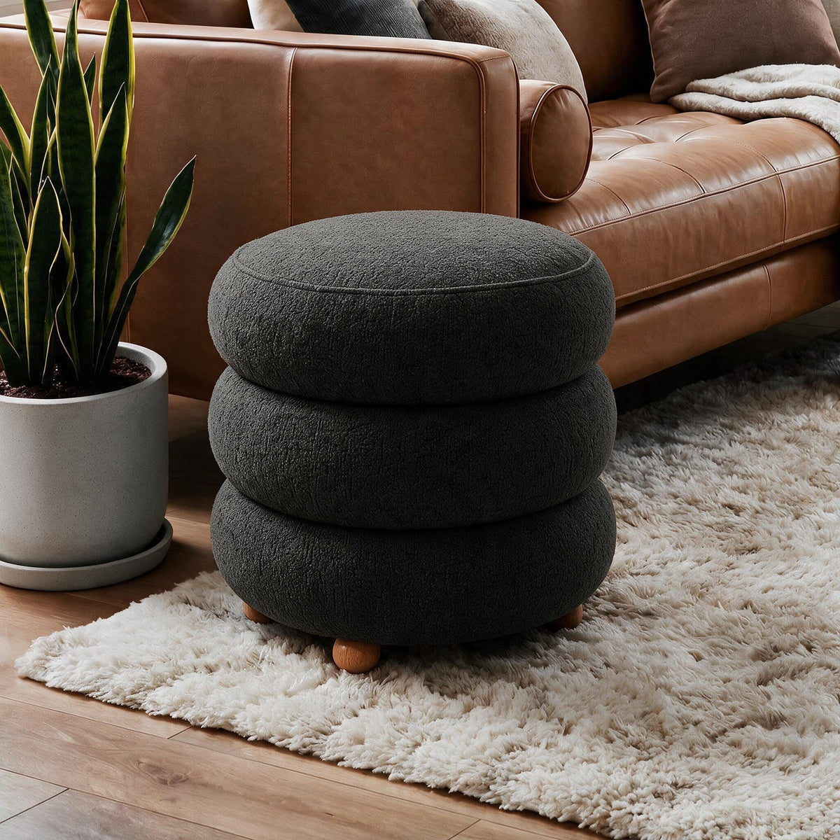 Dunkelgrauer Pouf Ottavia von Hanah Home mit gestricktem Polyesterbezug, Holzkugelfüssen und verborgenem Stauraum unter der Sitzfläche.