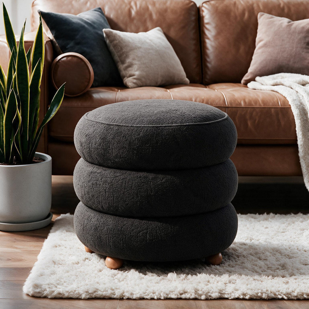 Dunkelgrauer Pouf Ottavia von Hanah Home mit gestricktem Polyesterbezug, Holzkugelfüssen und verborgenem Stauraum unter der Sitzfläche.