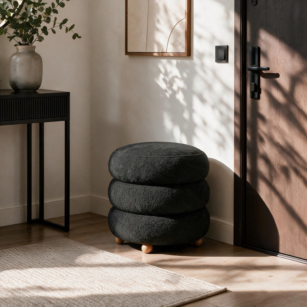 Dunkelgrauer Pouf Ottavia von Hanah Home mit gestricktem Polyesterbezug, Holzkugelfüssen und verborgenem Stauraum unter der Sitzfläche.