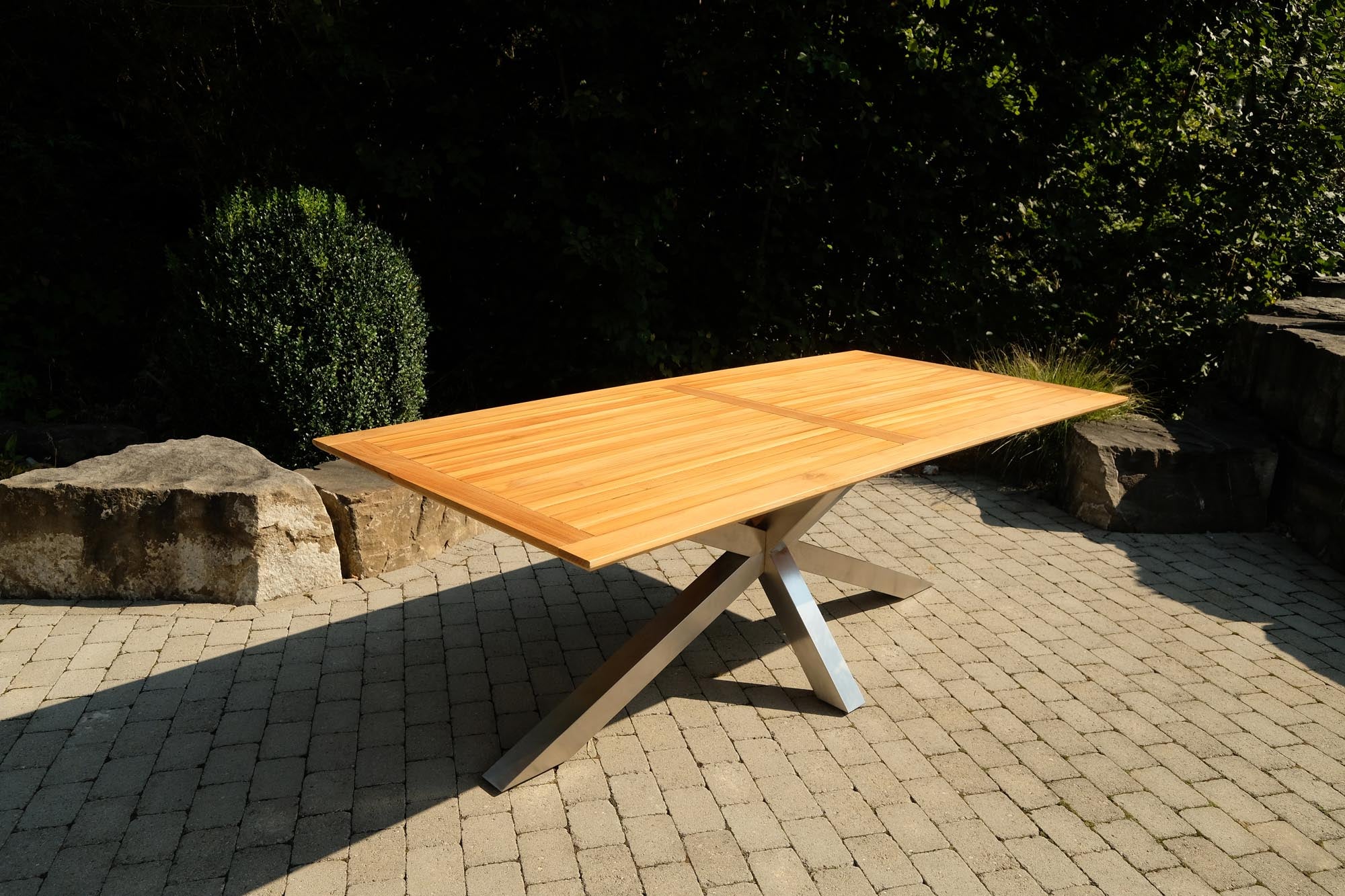 Moderner Gartentisch Monaco mit robusten XX-Füßen und edler Teakplatte, perfekt für gemütliche Stunden im Freien.