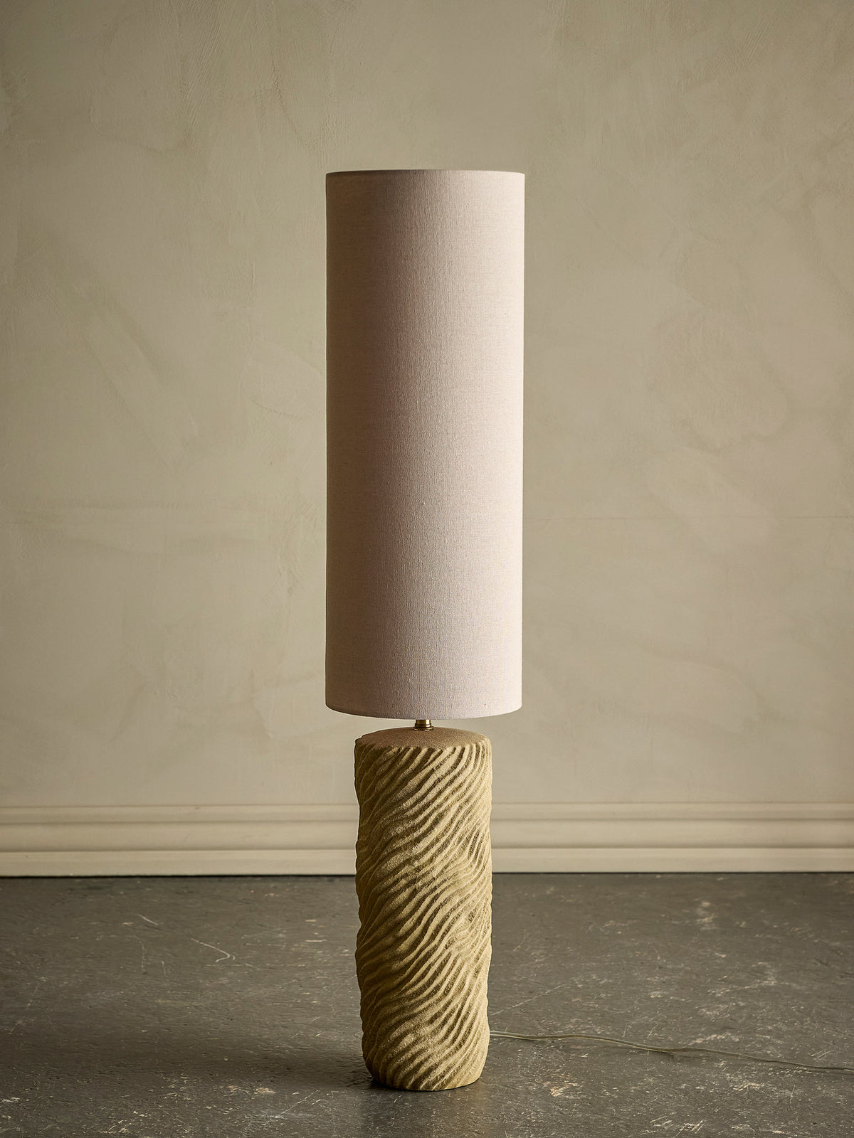 Stehlampe Payah in Beige von Bloomingville mit Fuss aus strukturiertem Steingut, Gestell aus Eisen und rundem Lampenschirm aus Polyester.