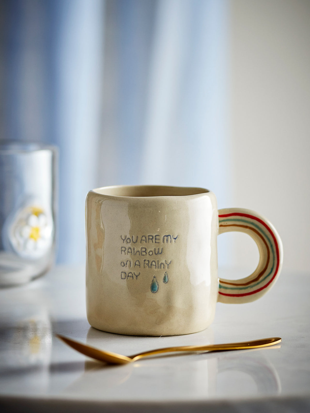 Weisse Cloudy Tasse aus Steingut mit Regenbogen als Griff und Schriftzug