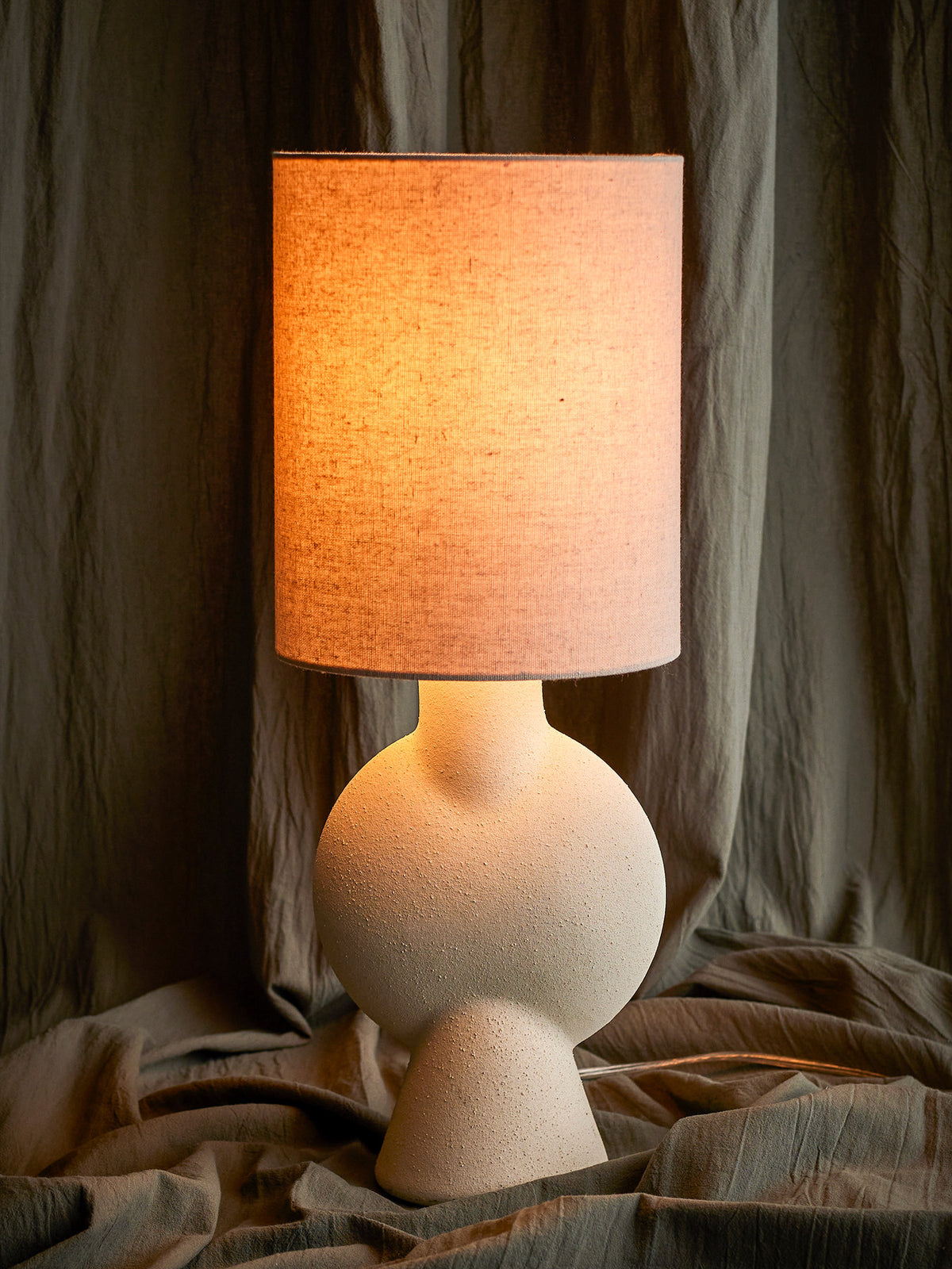 Weisse Tischlampe Sergio von Bloomingville aus Steingut mit rundem Fuss, schmalem Hals und Leinenschirm, Höhe 55 cm, Durchmesser 21 cm.