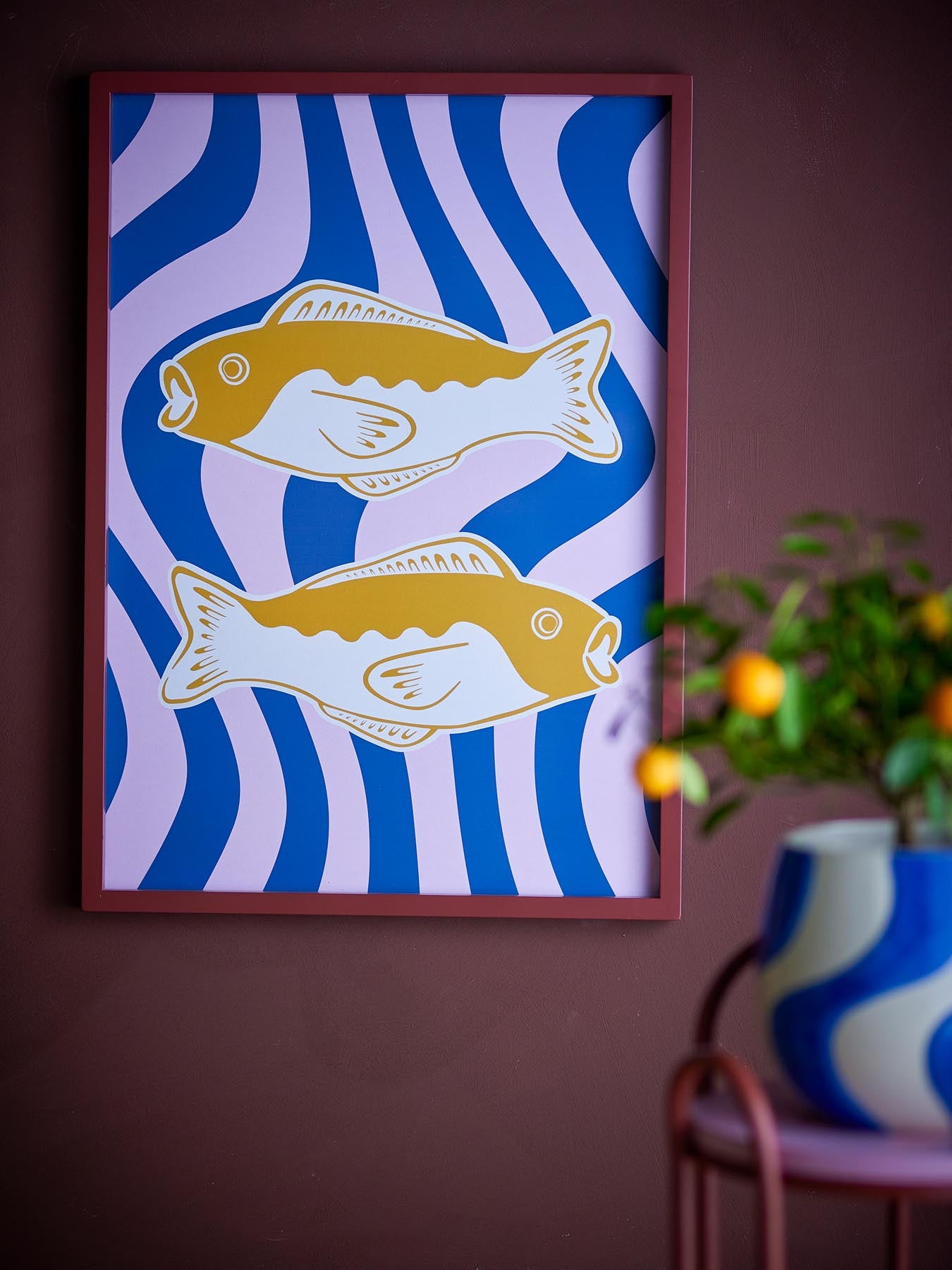 Bringen Sie mit der Remy Illustration von Bloomingville Farbe und Stil in Ihr Zuhause. Die verspielten Fische und der edle Kiefernholzrahmen schaffen eine einladende Atmosphäre.