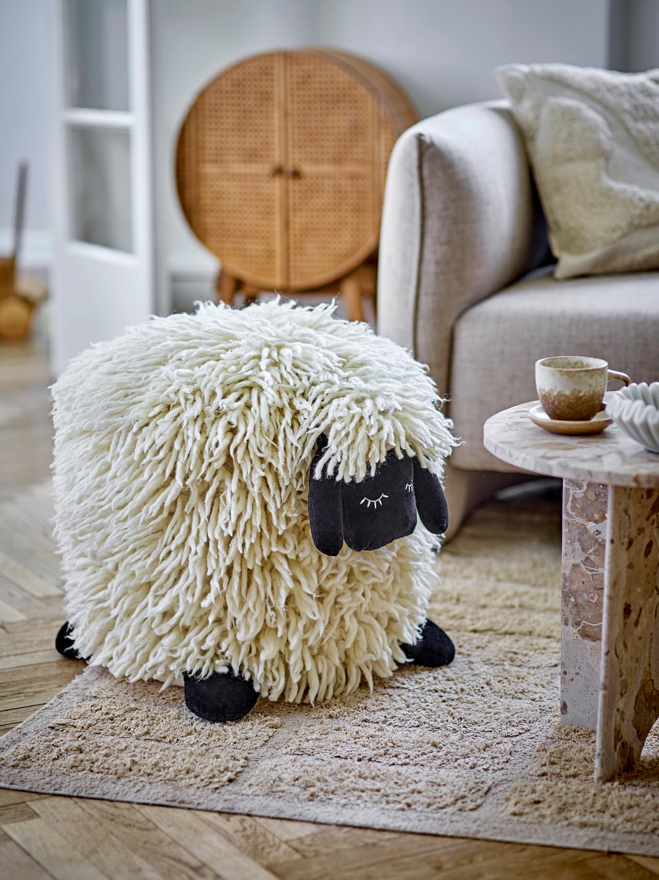 Der Dolly Pouf in Weiß von Bloomingville MINI ist ein stilvolles, vielseitiges Möbelstück aus hochwertiger Wolle, das jedem Raum eine gemütliche Note verleiht.