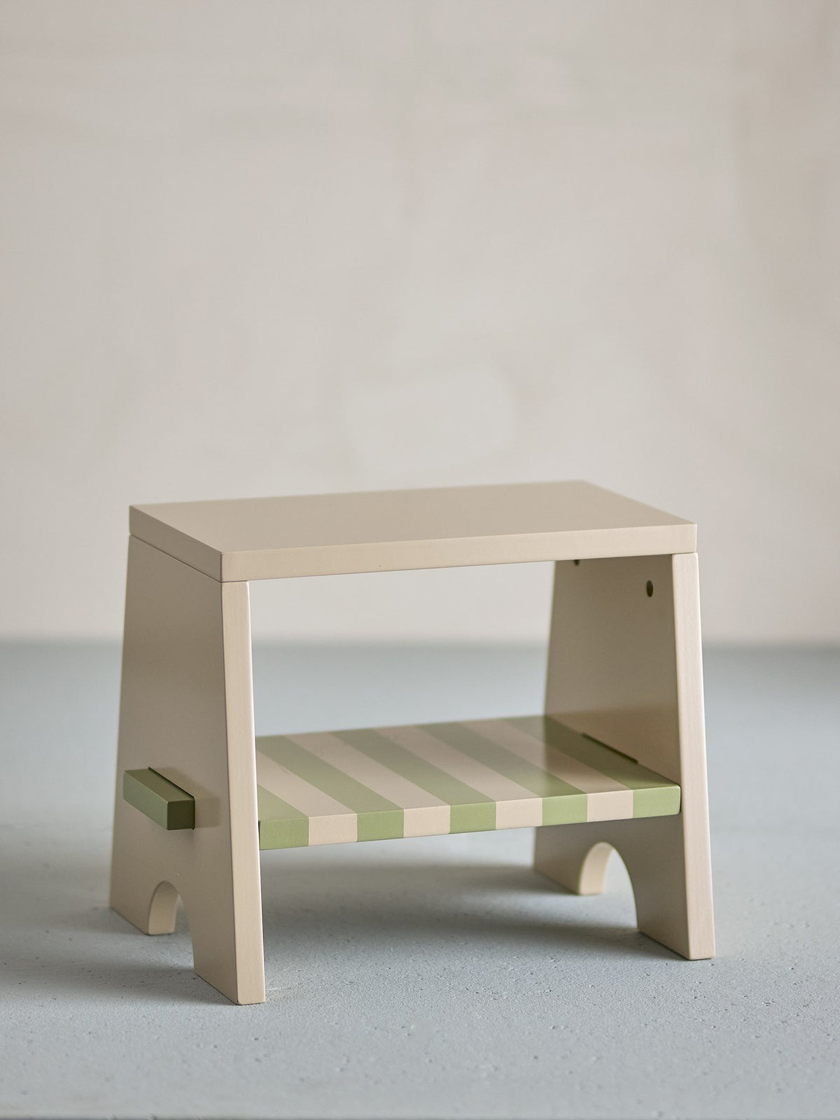 Liova Hocker von Bloomingville Mini aus lackiertem MDF, hellgelber Rahmen mit rosafarbenen Streifen auf der Sitzfläche, kleine Sitzgelegenheit.