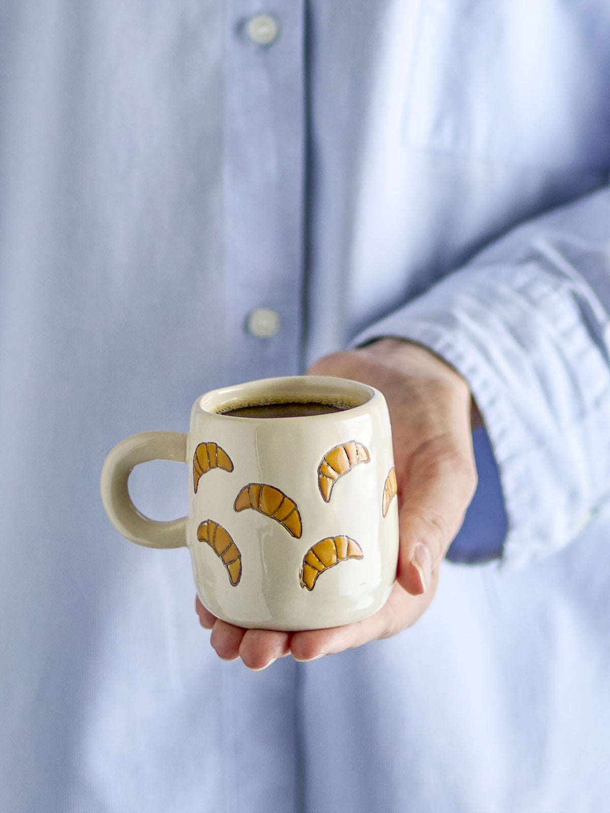 Millie Tasse von Bloomingville Mini aus Steingut, handbemalt mit Croissant-Motiven in Orange, Beige und Grün, kleine runde Form.