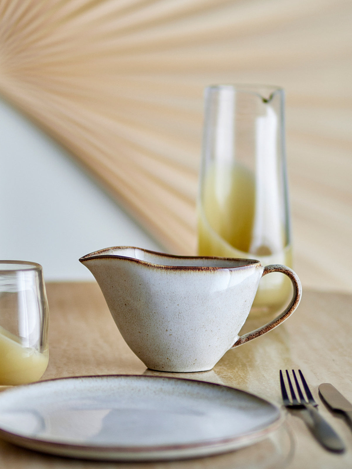 Beige Sauciere aus Steingut mit organischer Form, Henkel und Ausgiesser, reaktive Glasur, Serie Sandrine von Bloomingville auf hellem Hintergrund.