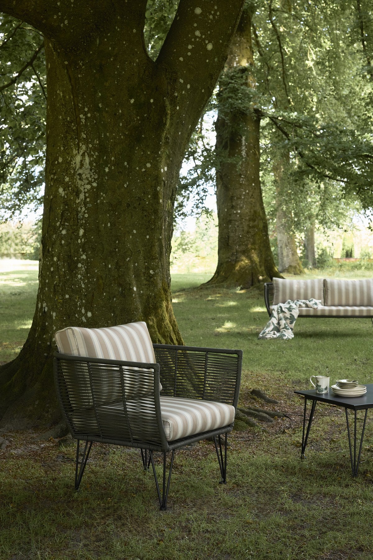 Schwarzer Mundo Couchtisch von Bloomingville aus Faserzement mit Eisenbeinen und länglicher Tischplatte für den Aussenbereich.