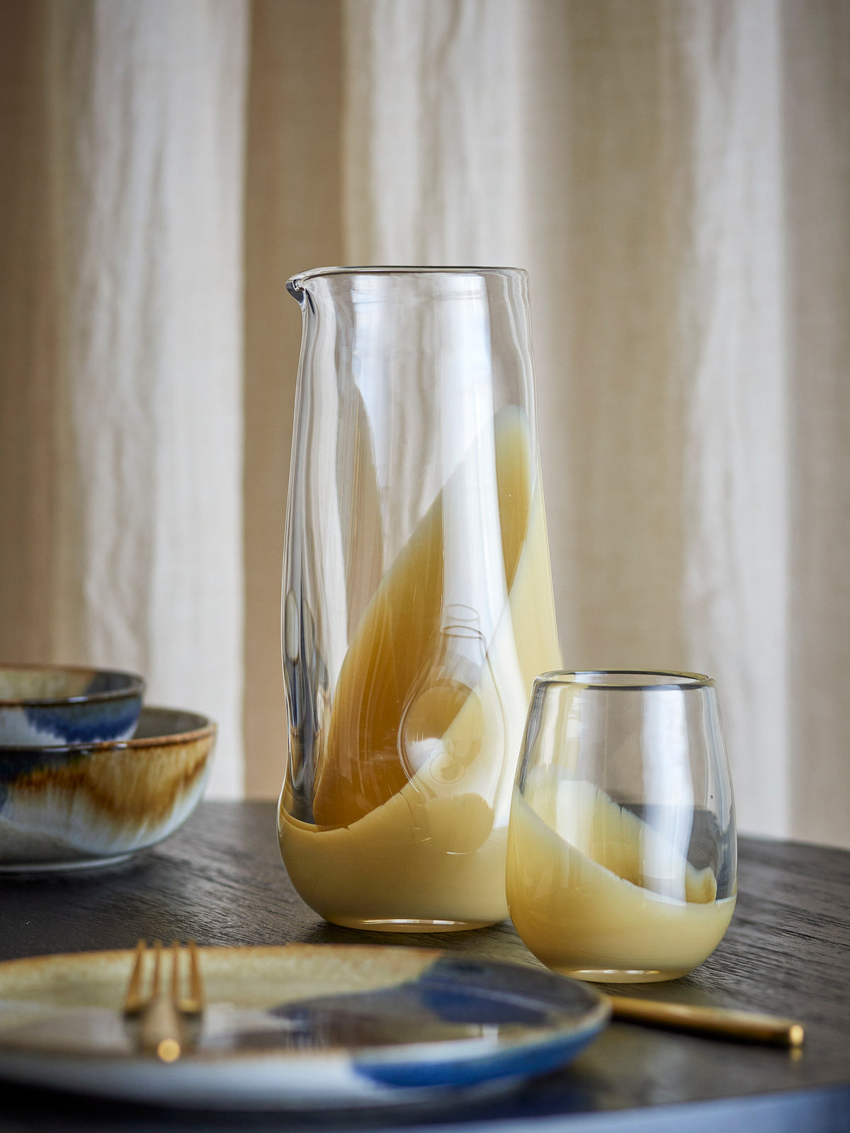 Ballard Krug von Bloomingville aus klarem Glas mit beigem Farbverlauf am Boden, schlanke Kannenform mit Henkel, Ansicht von vorne.