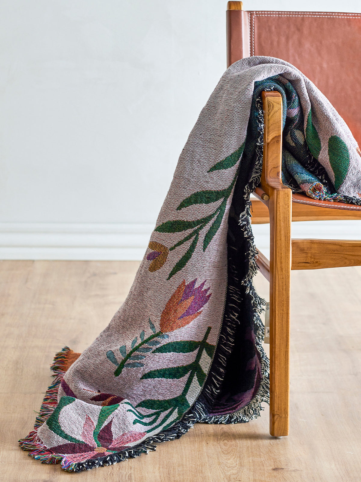 Gewebte Wolldecke Yash in Multi mit botanischem Muster auf beiden Seiten, Mischfasern aus Baumwolle, Polyester, Viskose und Wolle, mit bunten Fransen am Rand.