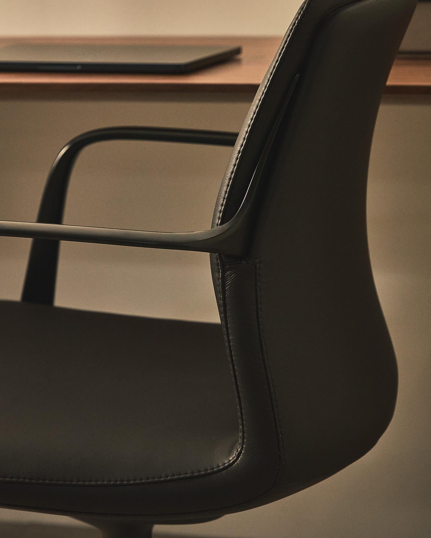 Erleben Sie den Schreibtischstuhl Nerlan von Kave Home: stilvolles Kunstleder, robustes Aluminiumgestell und ergonomische Unterstützung für produktives Arbeiten.