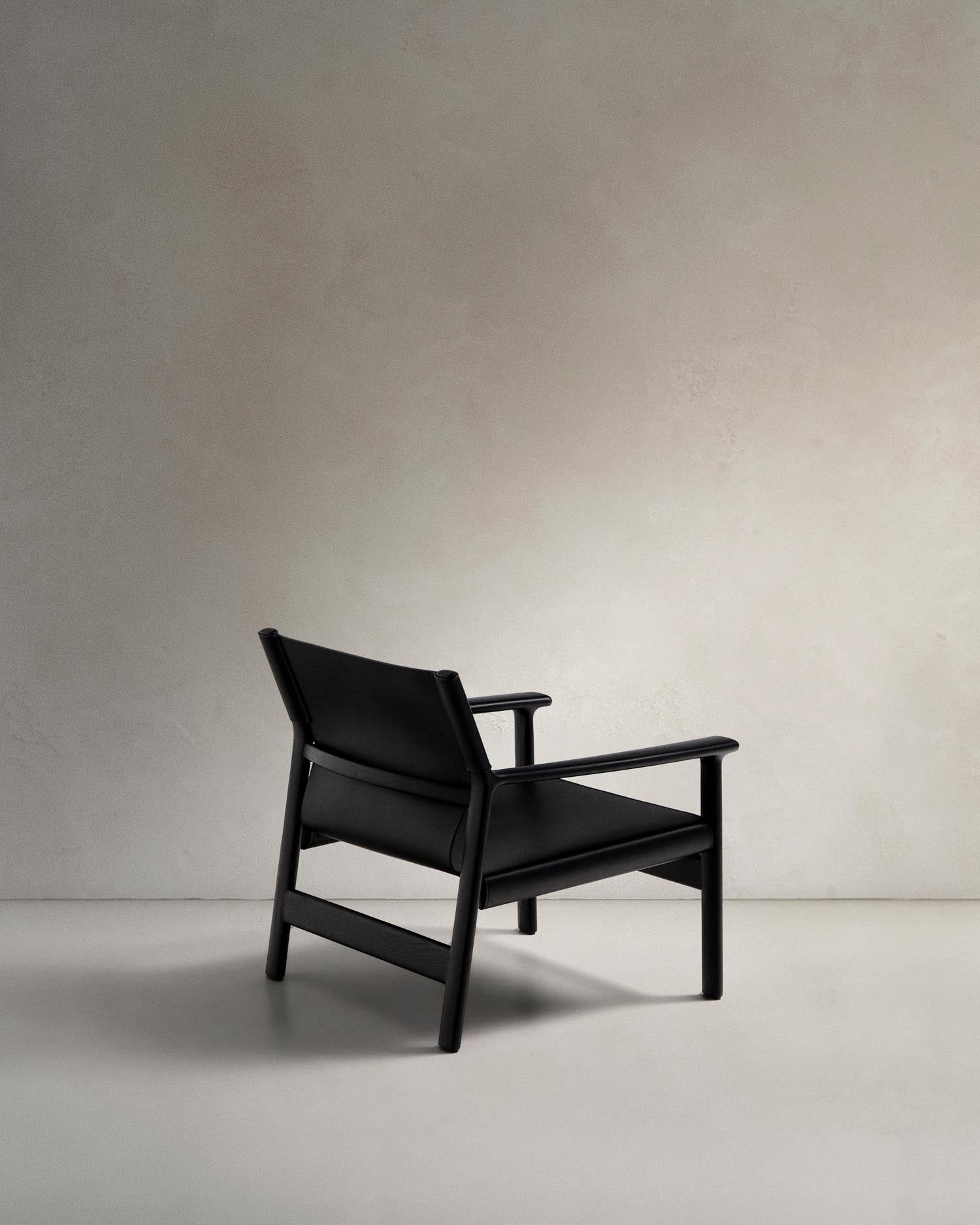 Entdecken Sie den Sessel Jan von Kave Home: Ein elegantes Möbelstück aus recyceltem Leder und FSC-zertifiziertem Eschenholz, das zeitlose Schönheit und Komfort vereint.