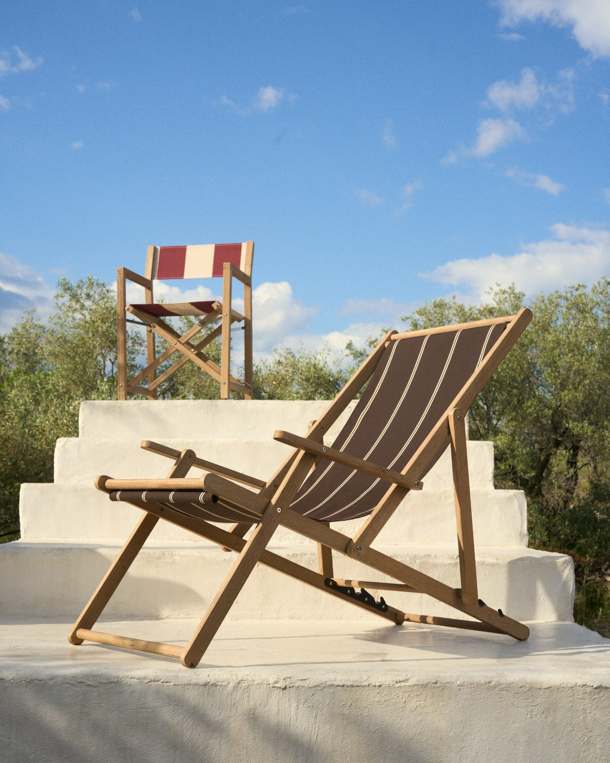 Braun-beige gestreifter Liegestuhl aus massivem Akazienholz mit klappbarem Gestell, Armlehnen und Stoffbespannung im Outdoor-Bereich.