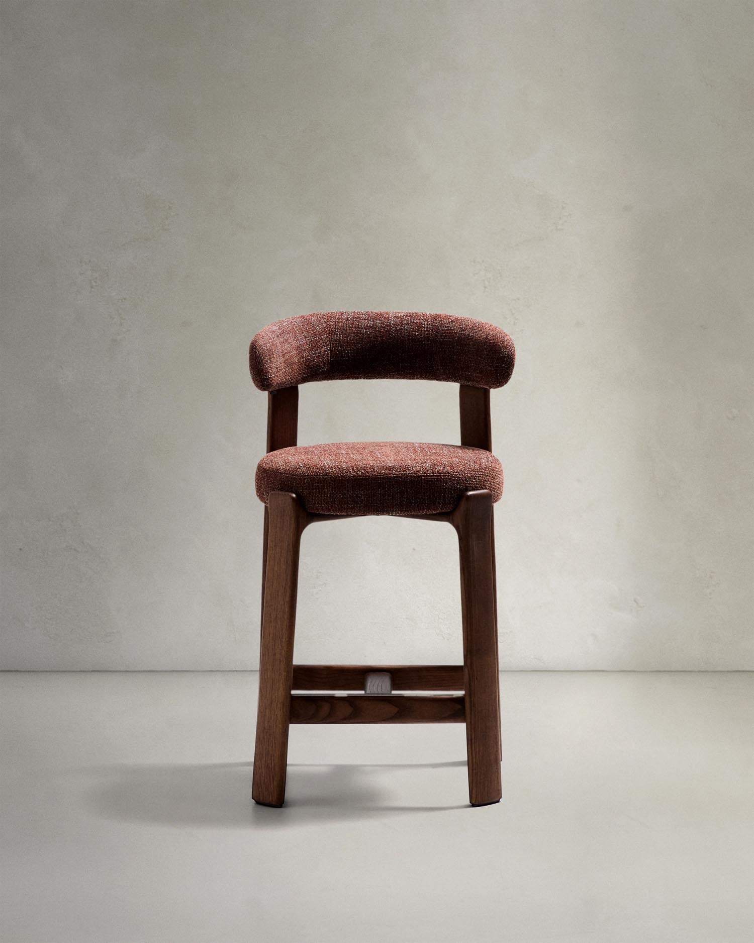 Entdecken Sie den Hocker Granite von Kave Home: Ein stilvoller Hocker aus brauner Chenille und massivem Eschenholz, ideal für Ihr Zuhause.