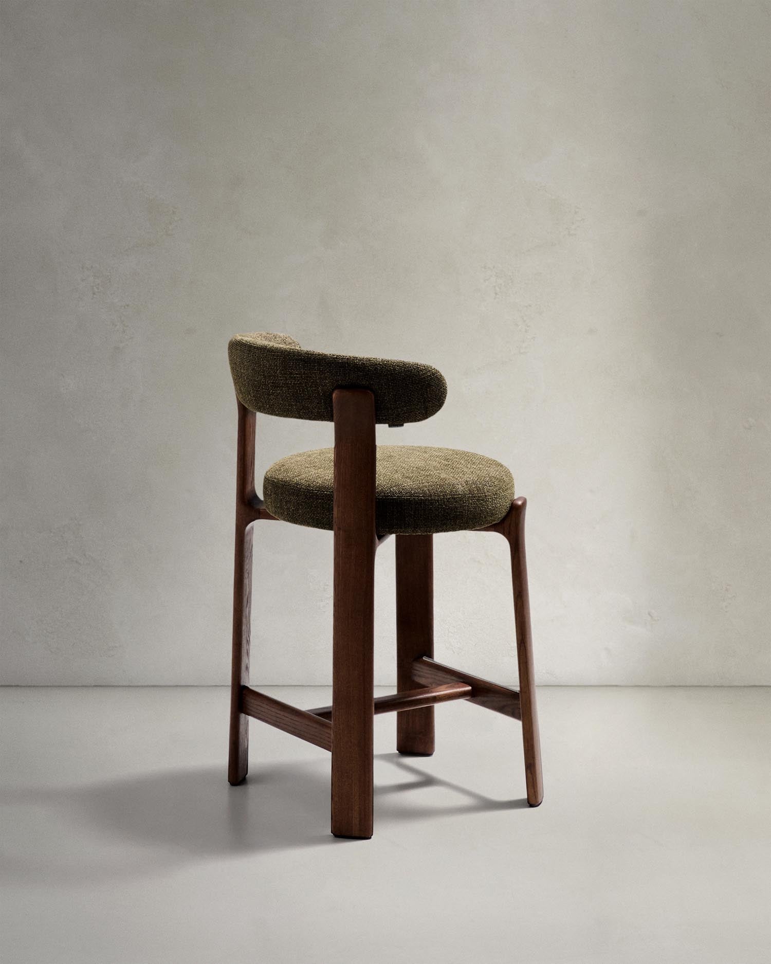 Hocker Granite: Eleganter Barhocker aus grüner Chenille und massivem Eschenholz, perfekt für stilvolle Küchentresen. Nachhaltig und zeitlos.