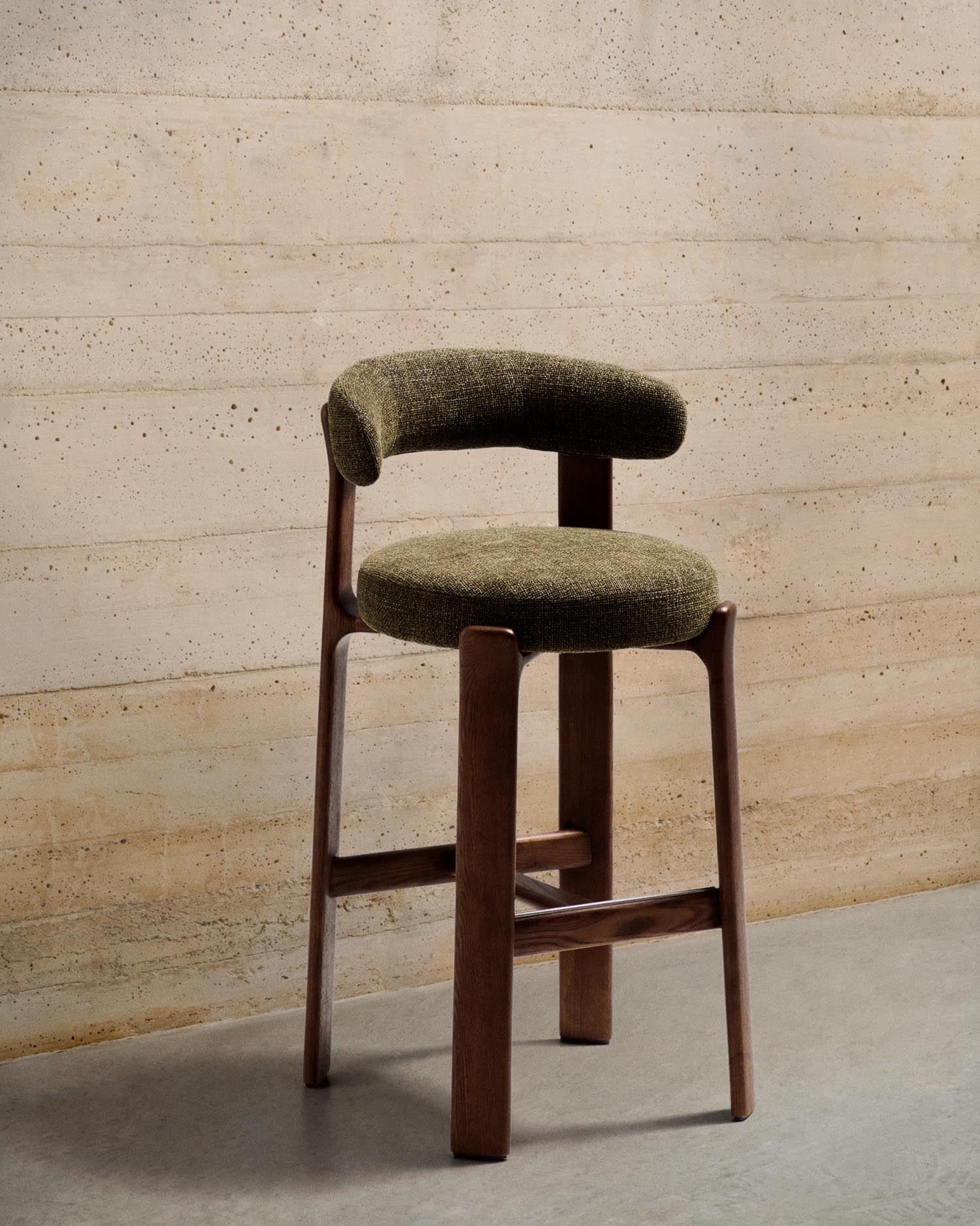 Entdecken Sie den Hocker Granite: Ein stilvoller Barhocker aus grüner Chenille und robustem Eschenholz, ideal für Ihr Zuhause.