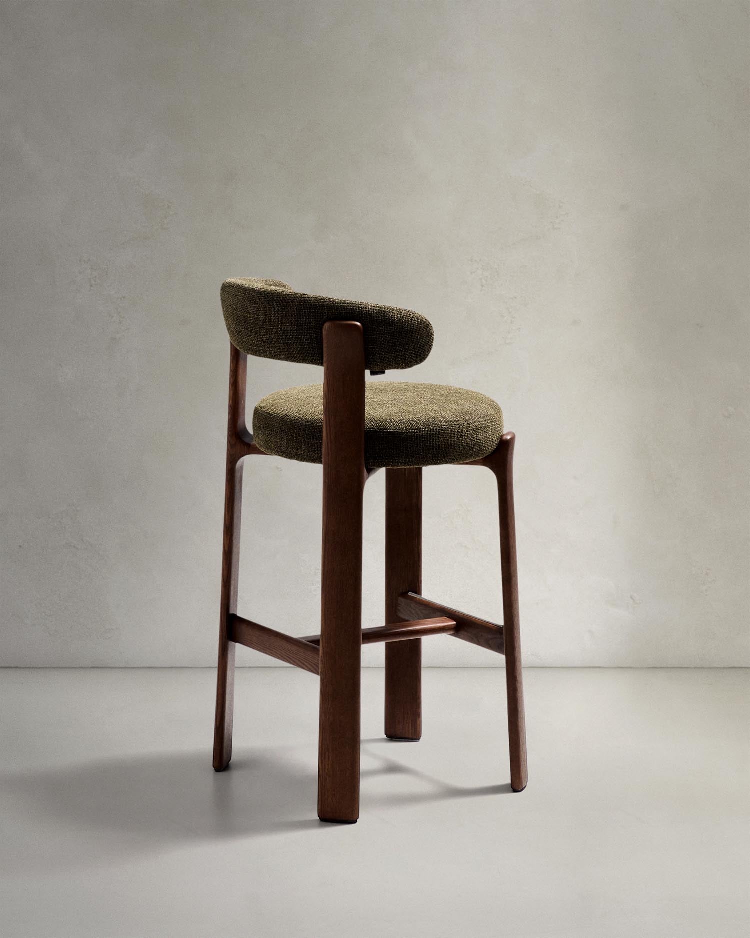 Erleben Sie den Hocker Granite von Kave Home: Ein eleganter Barhocker aus grünem Chenille und solidem Eschenholz, ideal für stilvolle Räume.