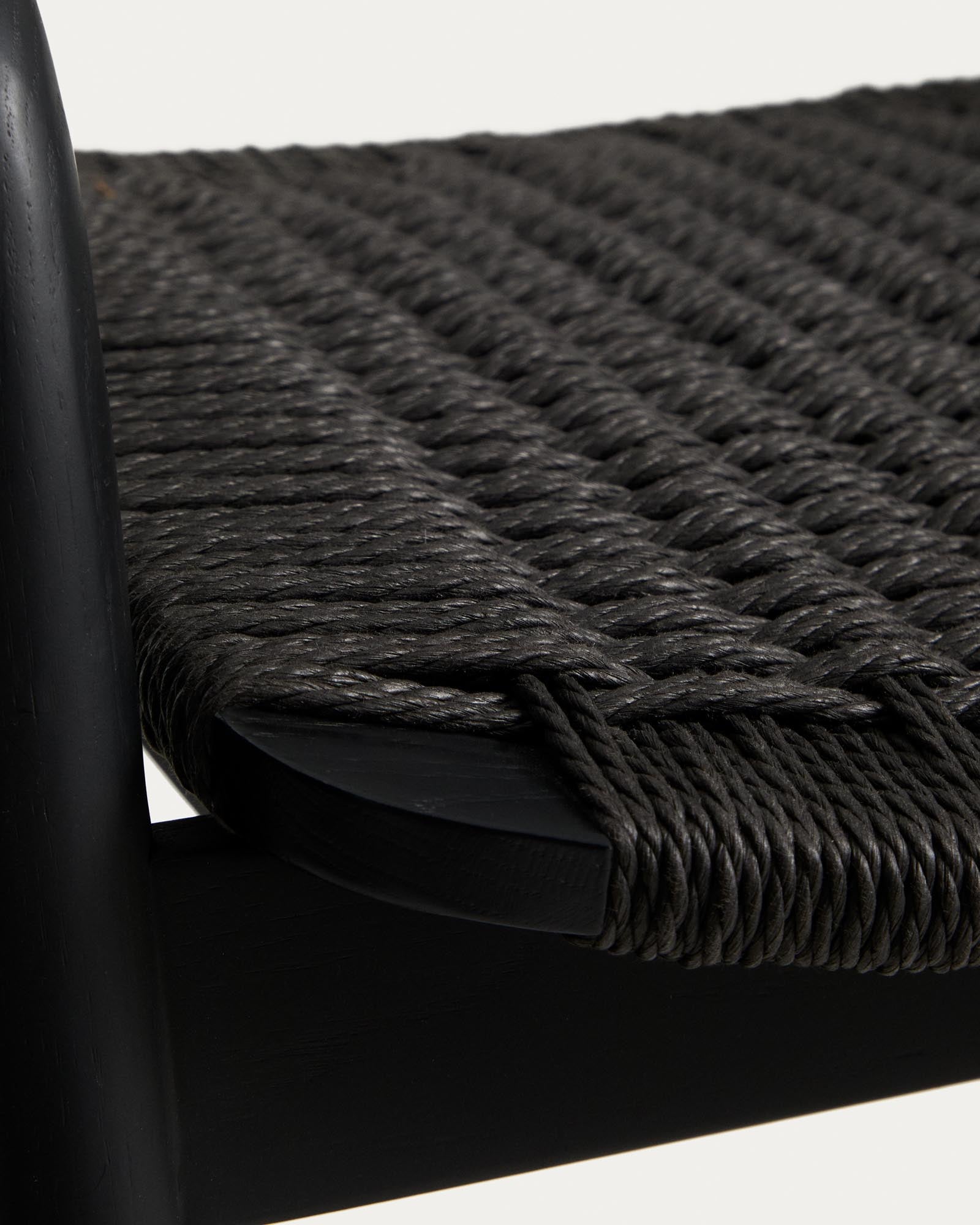 Eleganter Hocker Derile aus robustem Eichenholz in Schwarz, ausgestattet mit stilvollen Armlehnen und einem komfortablen Papierseil.