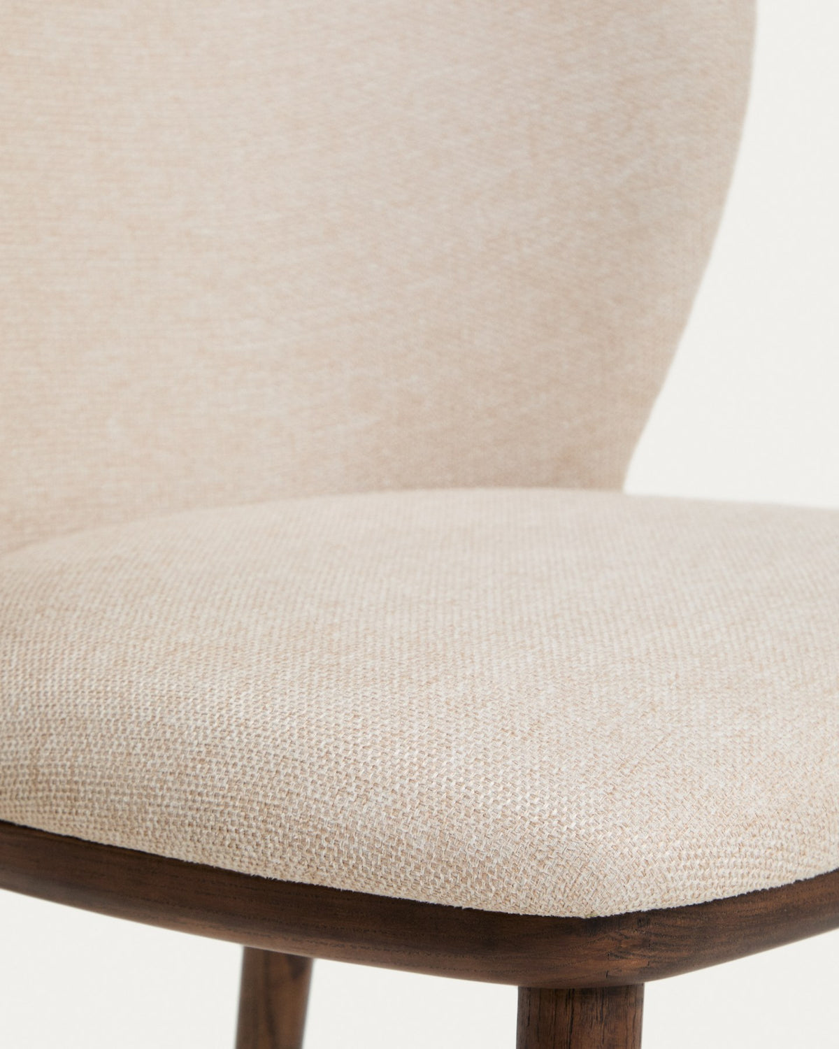 Stuhl Ciselia mit beigem Chenillebezug, gepolsterter Sitzfläche und Rückenlehne sowie Beinen aus massivem Eschenholz mit Walnuss-Finish.