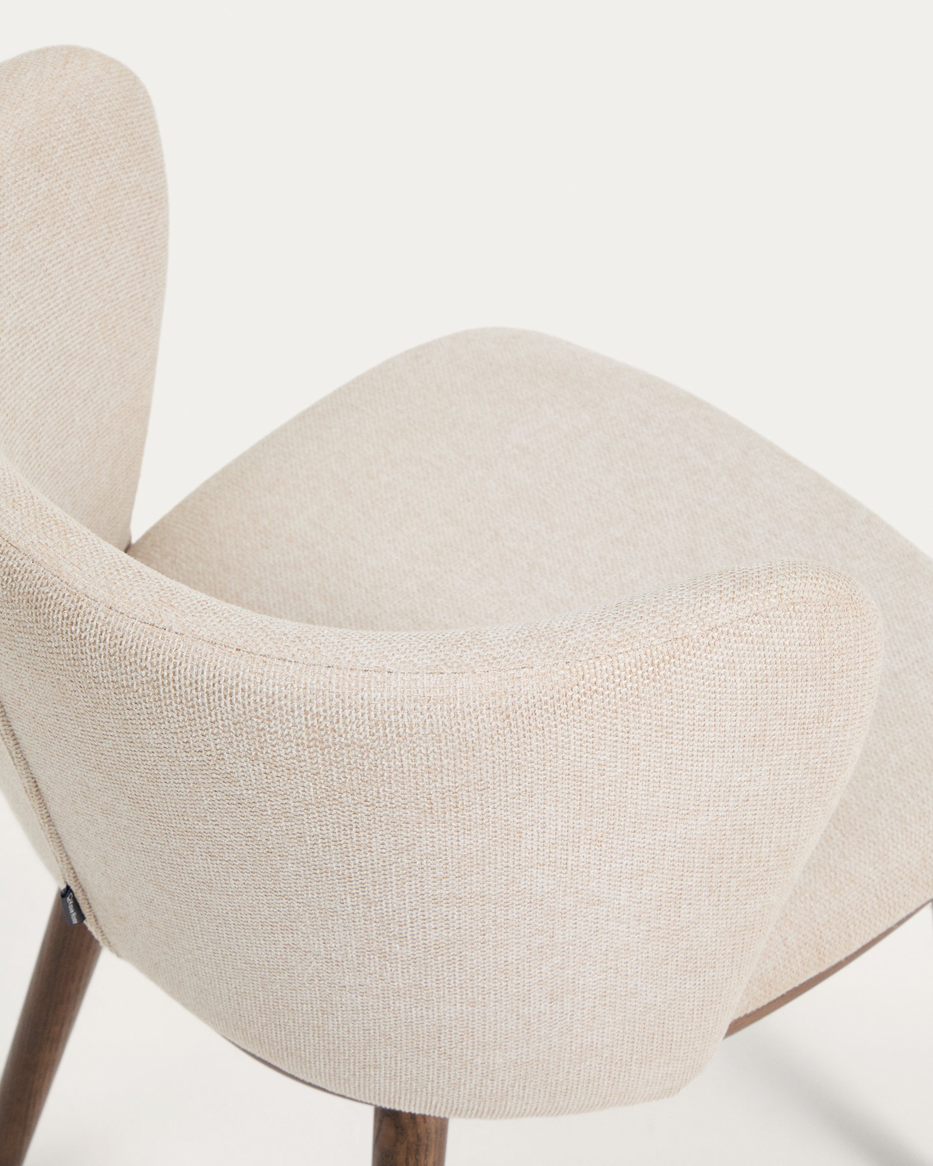 Eleganter Stuhl Ciselia in beigem Chenille, ausgestattet mit stabilen Eschenholzbeinen in Walnussholz-Optik, ideal für stilvolle Wohnräume.