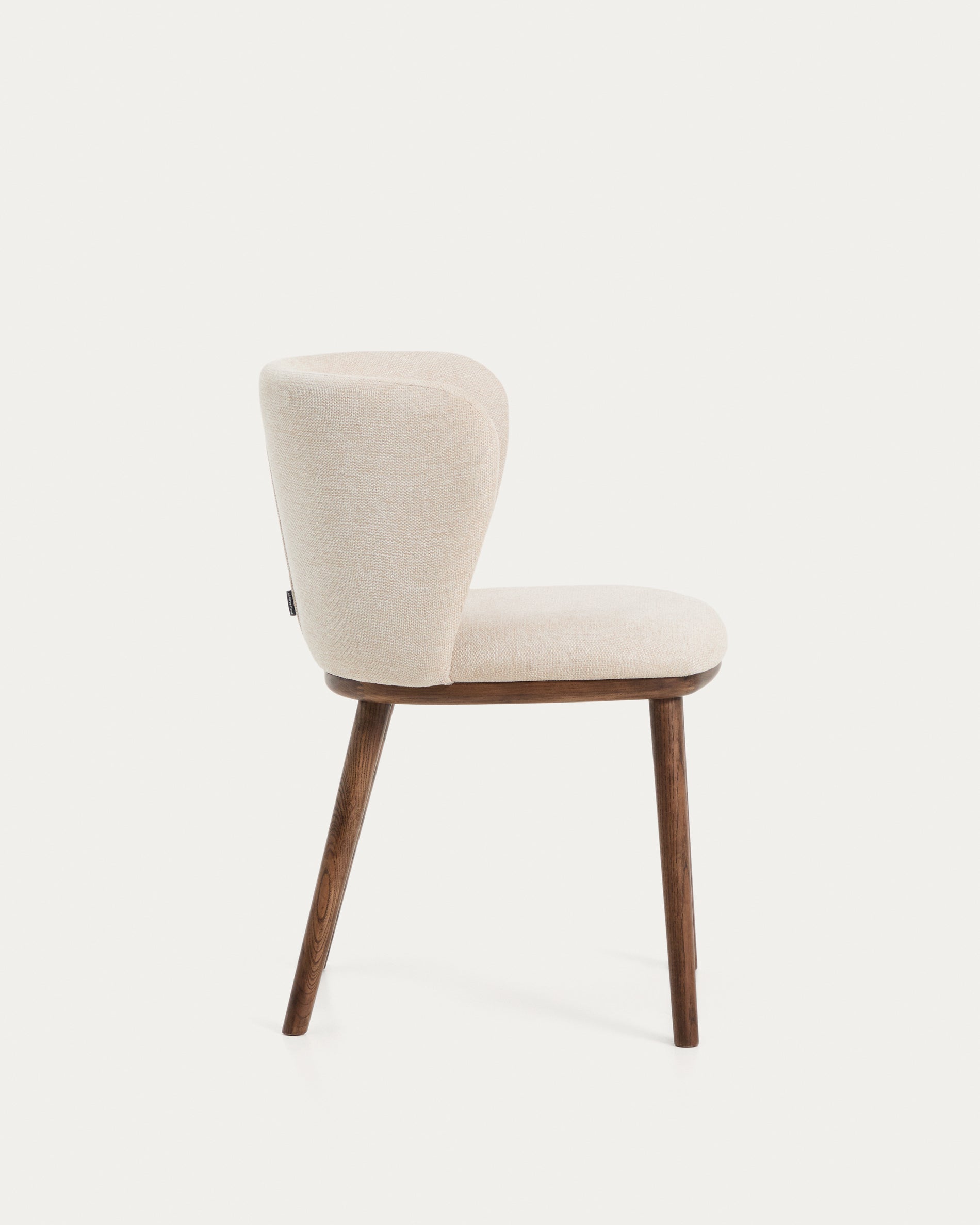 Eleganter Stuhl Ciselia in beigem Chenille, ausgestattet mit stabilen Eschenholzbeinen in Walnussholz-Optik, ideal für stilvolle Wohnräume.