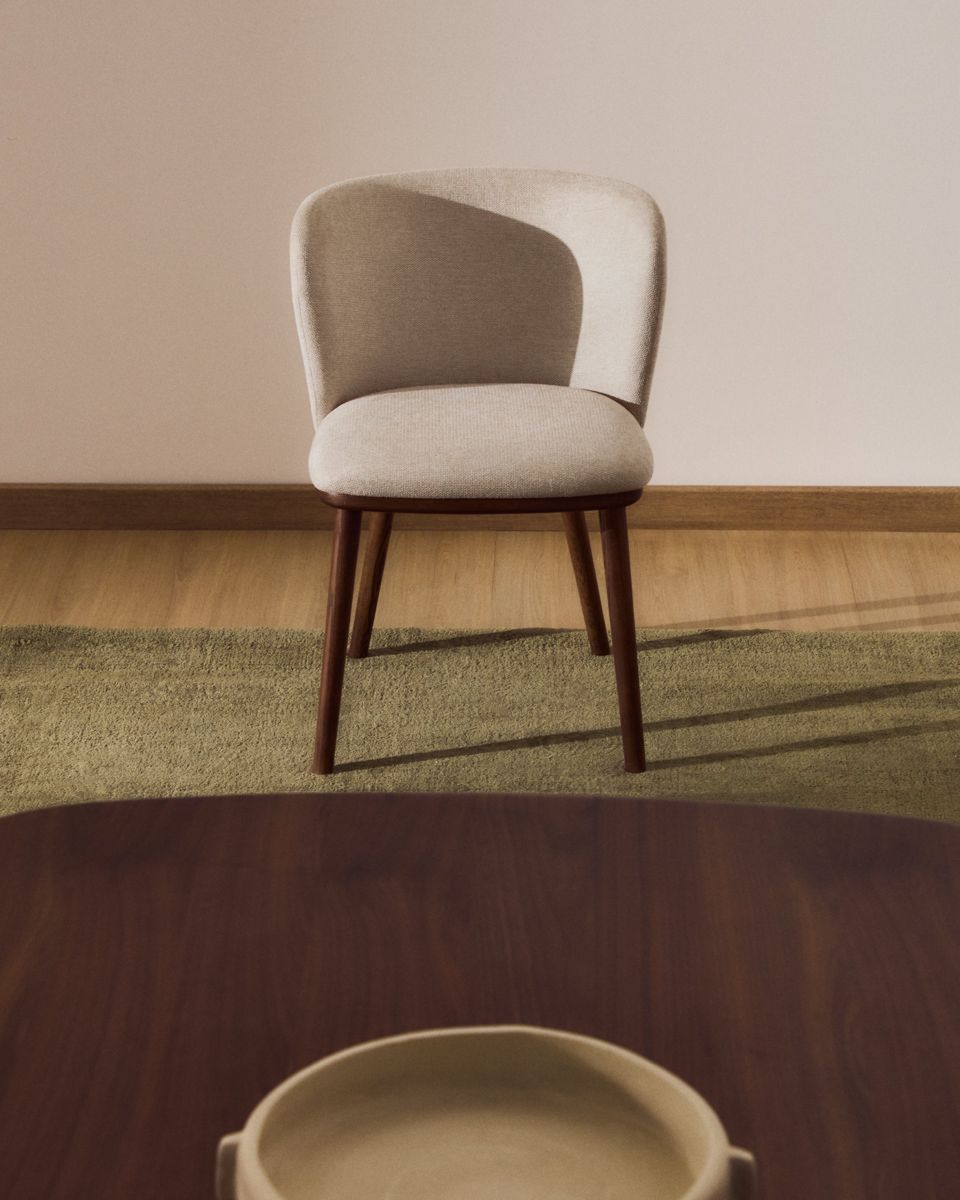 Eleganter Ciselia Stuhl in beiger Chenille, ausgestattet mit stabilen Eschenholzbeinen in Walnussholzfarbe, ideal für stilvolle Wohnräume.