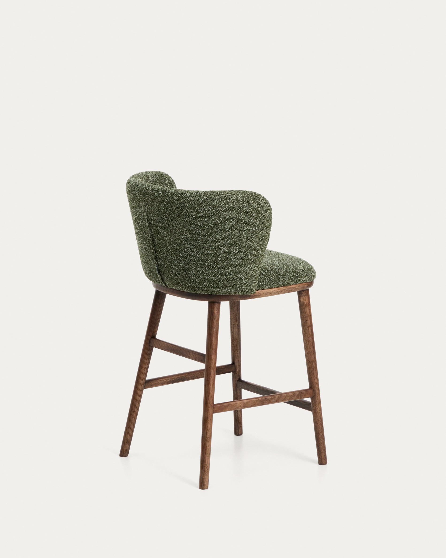 Stylischer Hocker Ciselia in tiefgrünem Chenille, mit robusten Eschenholzbeinen in warmem Walnussholz-Finish, ideal für moderne Barbereiche.