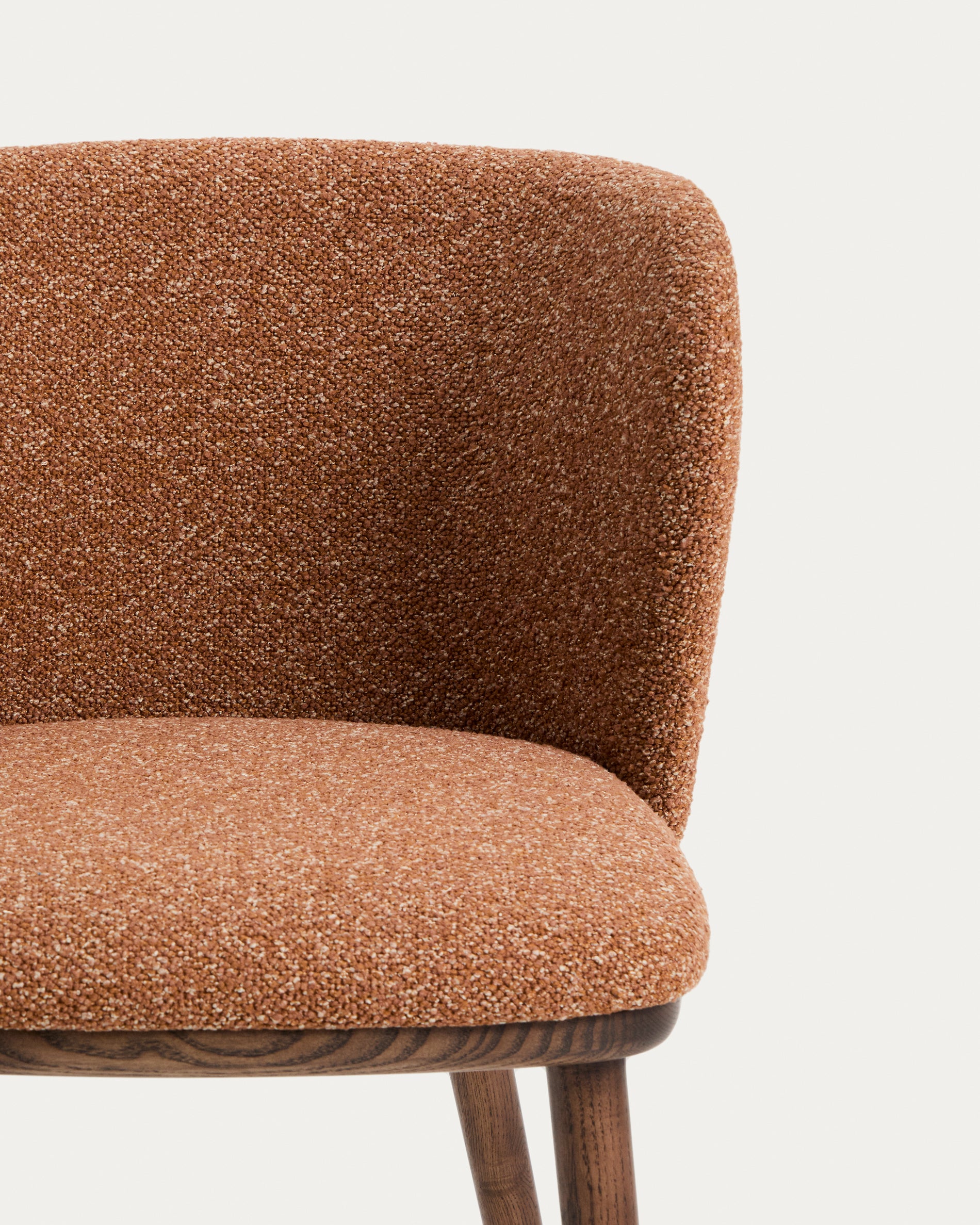Stylischer Hocker Ciselia aus dickem, terrakottafarbenem Chenille, mit robusten Eschenholzbeinen in edler Walnussfarbe, perfekt für moderne Wohnräume.