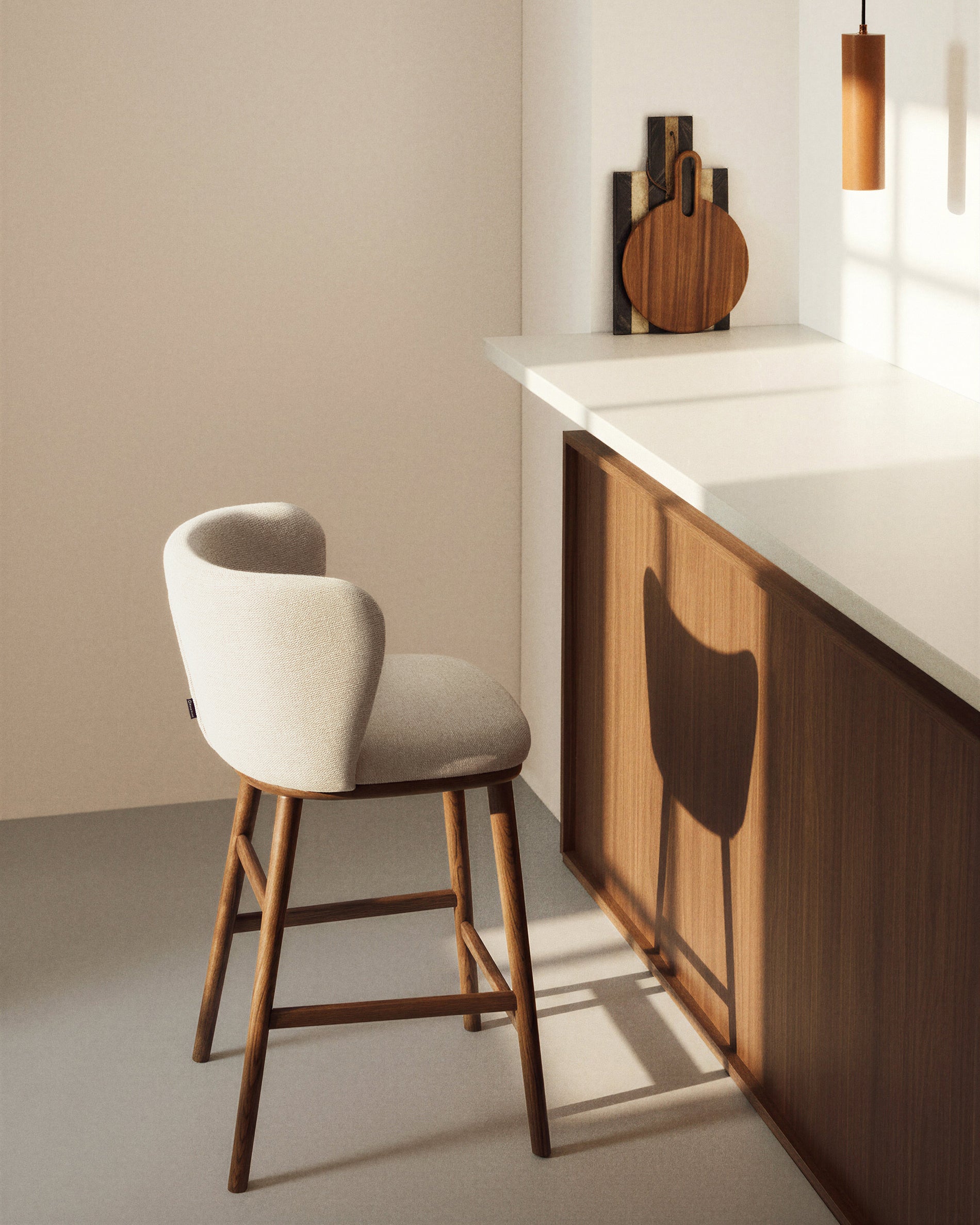 Eleganter Hocker Ciselia in beiger Chenille, ausgestattet mit stabilen Eschenholzbeinen in Walnussholzoptik, ideal für stilvolle Barbereiche.