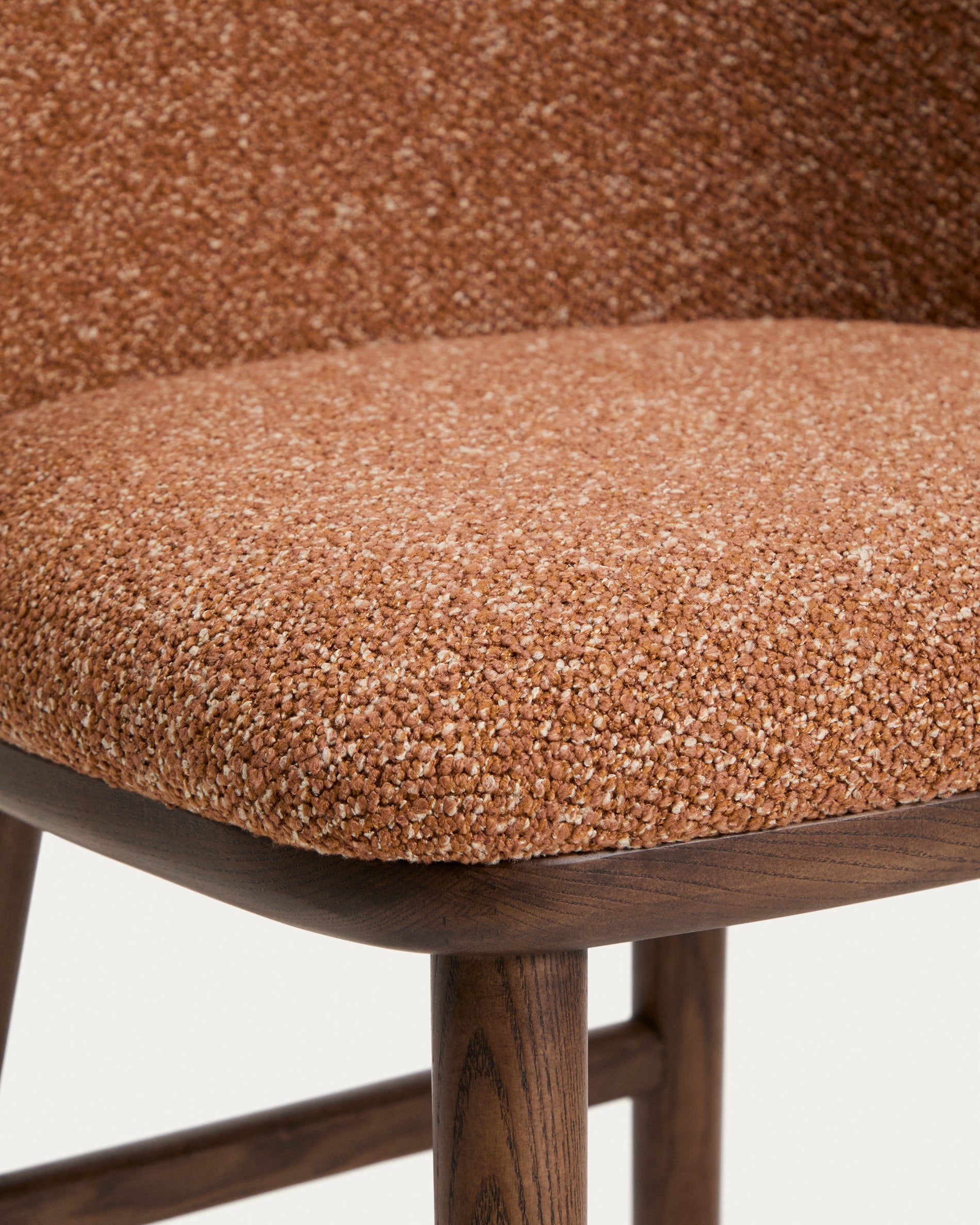 Eleganter Hocker Ciselia aus weichem, terrakottafarbenem Chenille, ausgestattet mit stabilen Eschenholzbeinen in Walnussholz-Optik, ideal für stilvolle Sitzgelegenheiten.