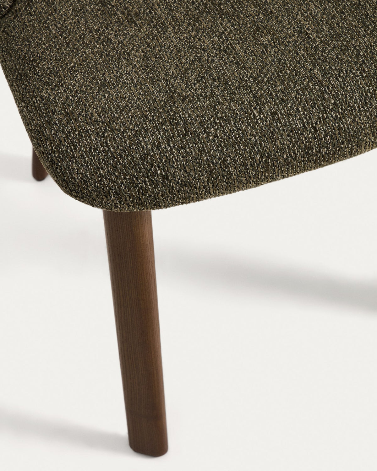 Stuhl Meila mit grünem Chenille-Bezug, durchgehender Rückenlehne und Beinen aus massivem Eschenholz mit Nussbaumfinish, Frontalansicht.
