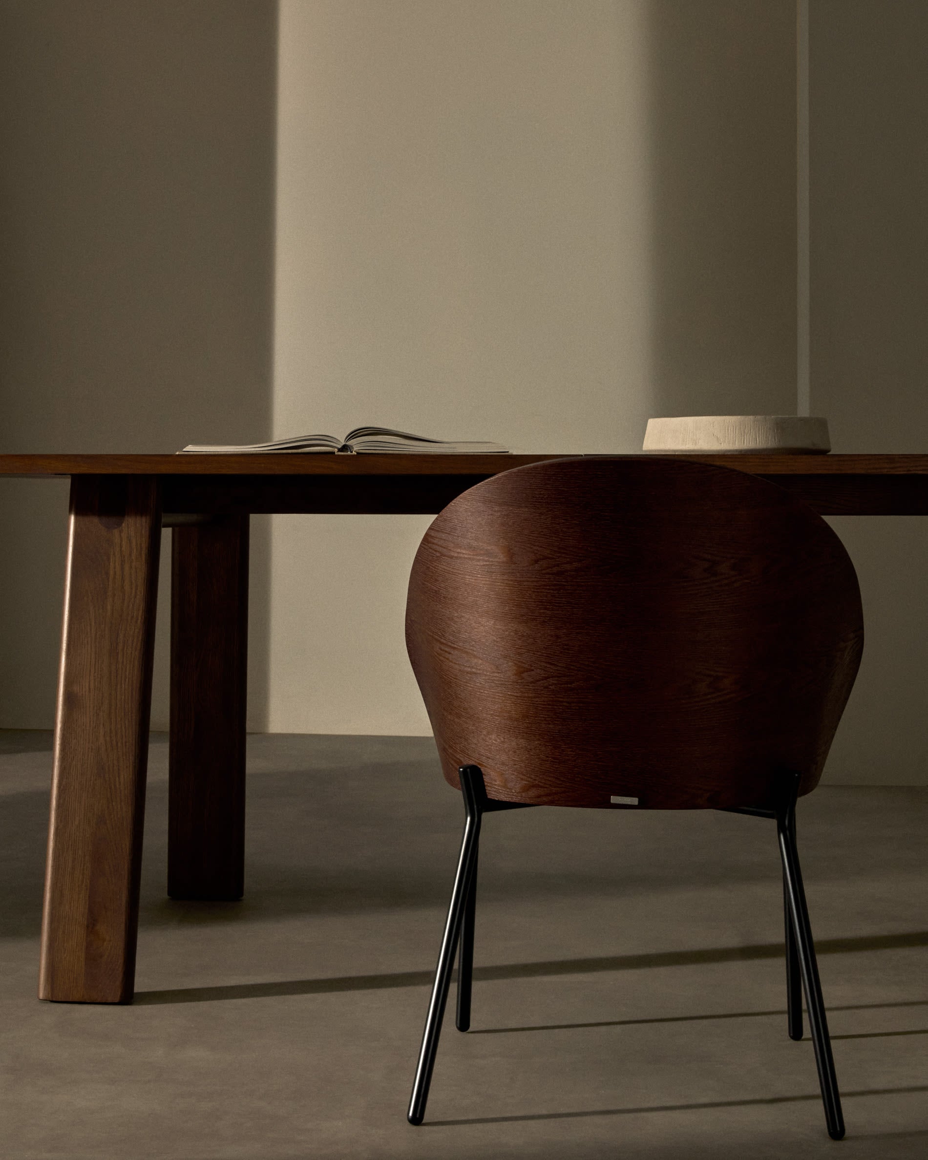 Moderner Eamy Stuhl aus braunem Kunstleder, Nussbaum-Furnier und robustem schwarzem Metallgestell – ideal für stilvolle Esszimmer und Büros.