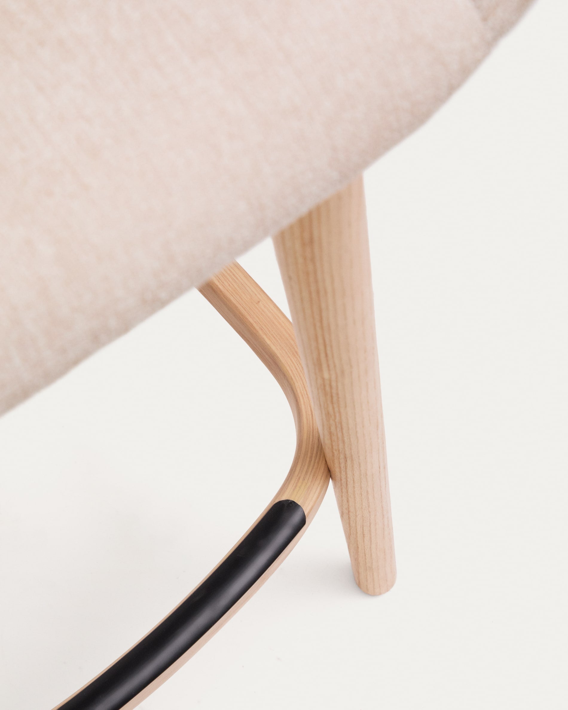 Beigefarbener Hocker Konna von Kave Home: 65 cm hoch, mit robusten Eschenholzbeinen und komfortablem, pflegeleichtem Stoff – perfekt für stilvolle Wohnräume.