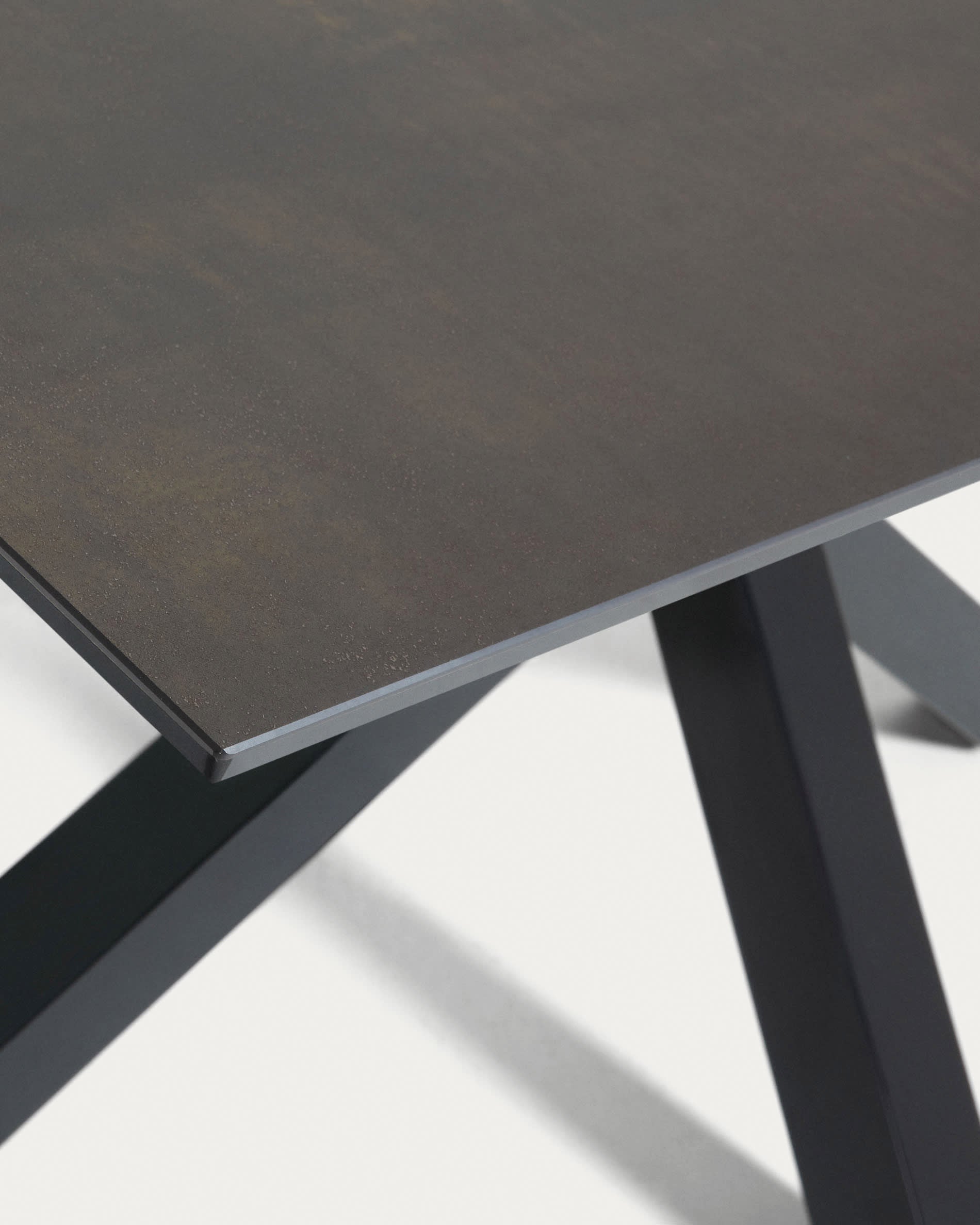 Entdecken Sie den eleganten Tisch Argo von Kave Home: Robuste Iron Moss-Porzellanplatte, stabile schwarze Stahlbeine, ideal für gesellige Anlässe.