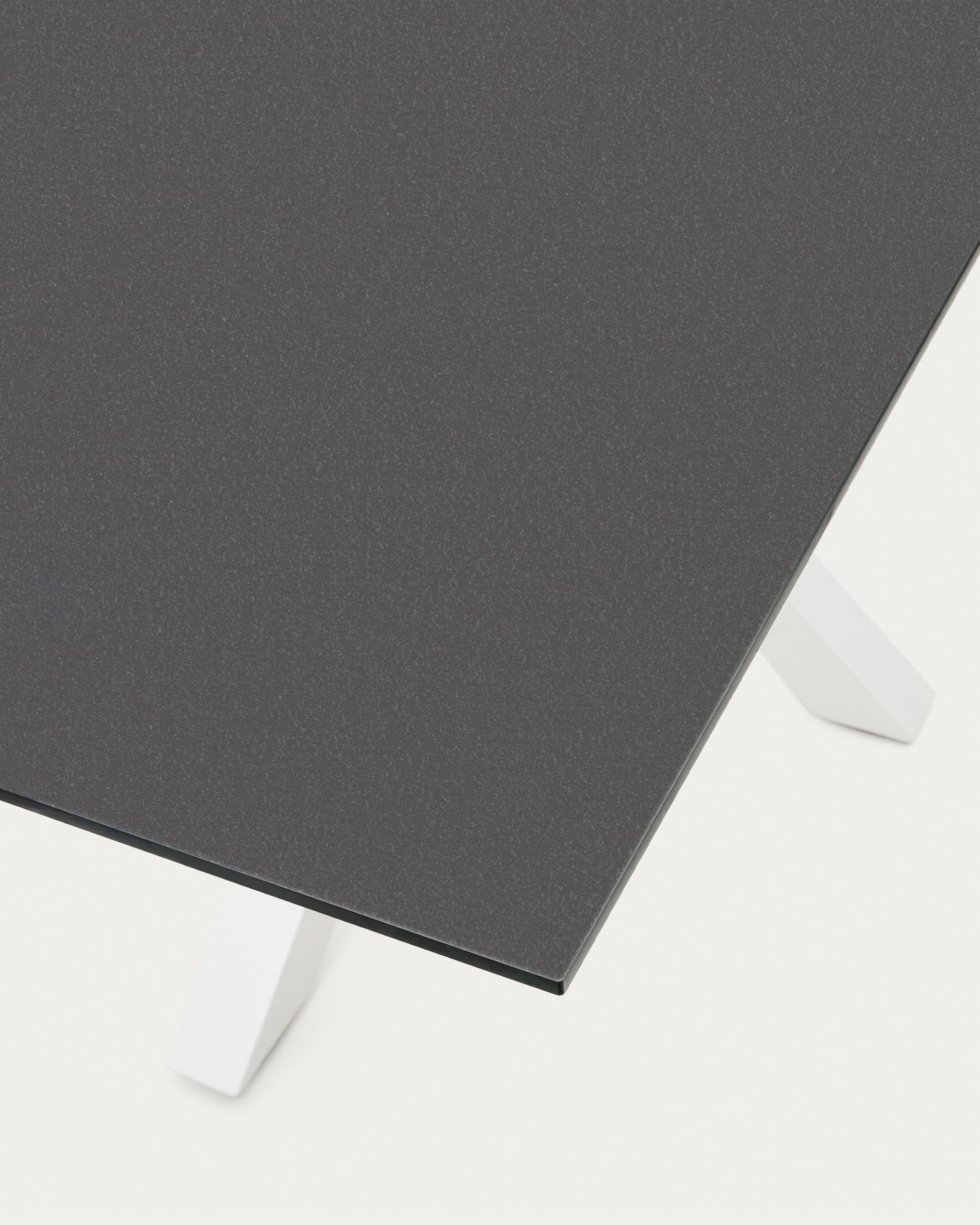 Der Tisch Argo von Kave Home vereint stilvolles schwarzes Milchglas mit stabilen, weißen Stahlbeinen und bietet Platz für gesellige Abende.