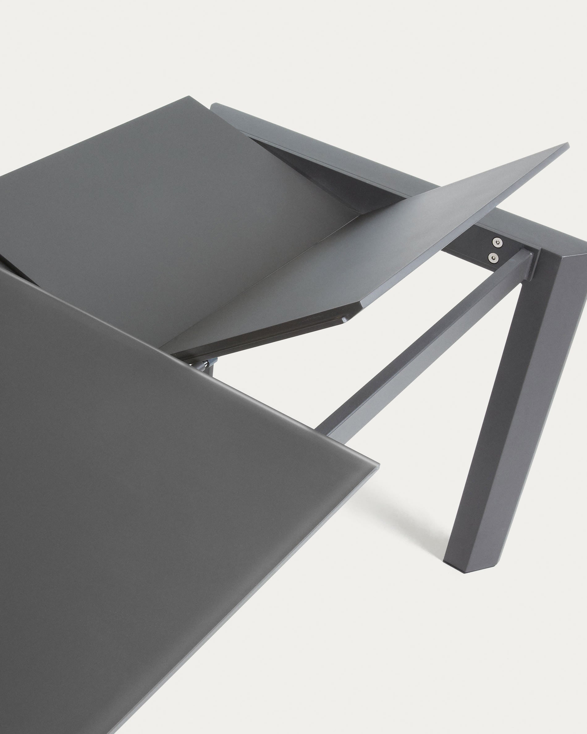 Moderner Ausziehtisch Axis von Kave Home: Graue Glasplatte, stabile Stahlbeine in Dunkelgrau, flexibel von 160 auf 220 cm erweiterbar.