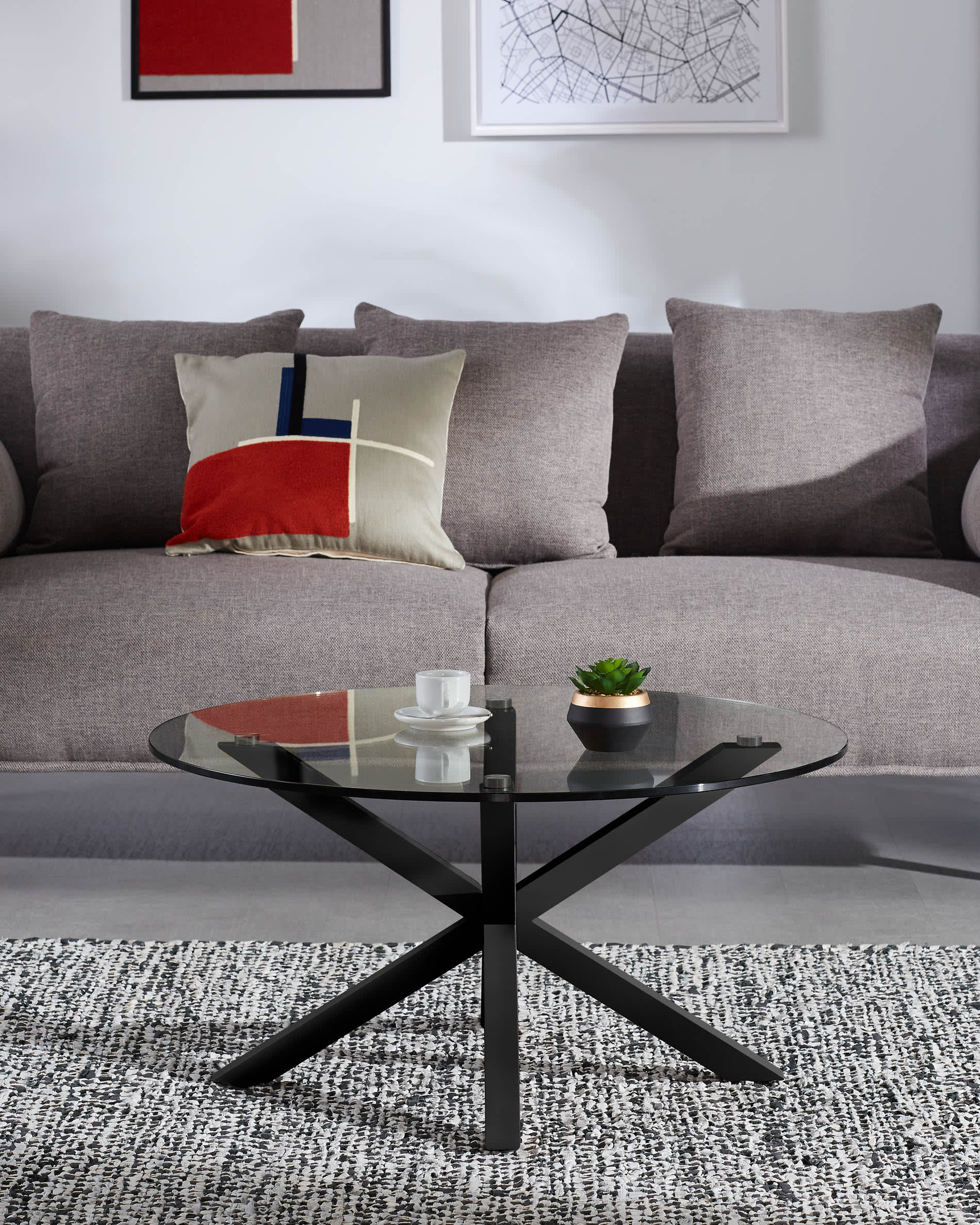 Eleganter Couchtisch Argo Ø 82 cm mit Glasplatte und schwarzen Stahlbeinen, perfekt für modernes Wohndesign.
