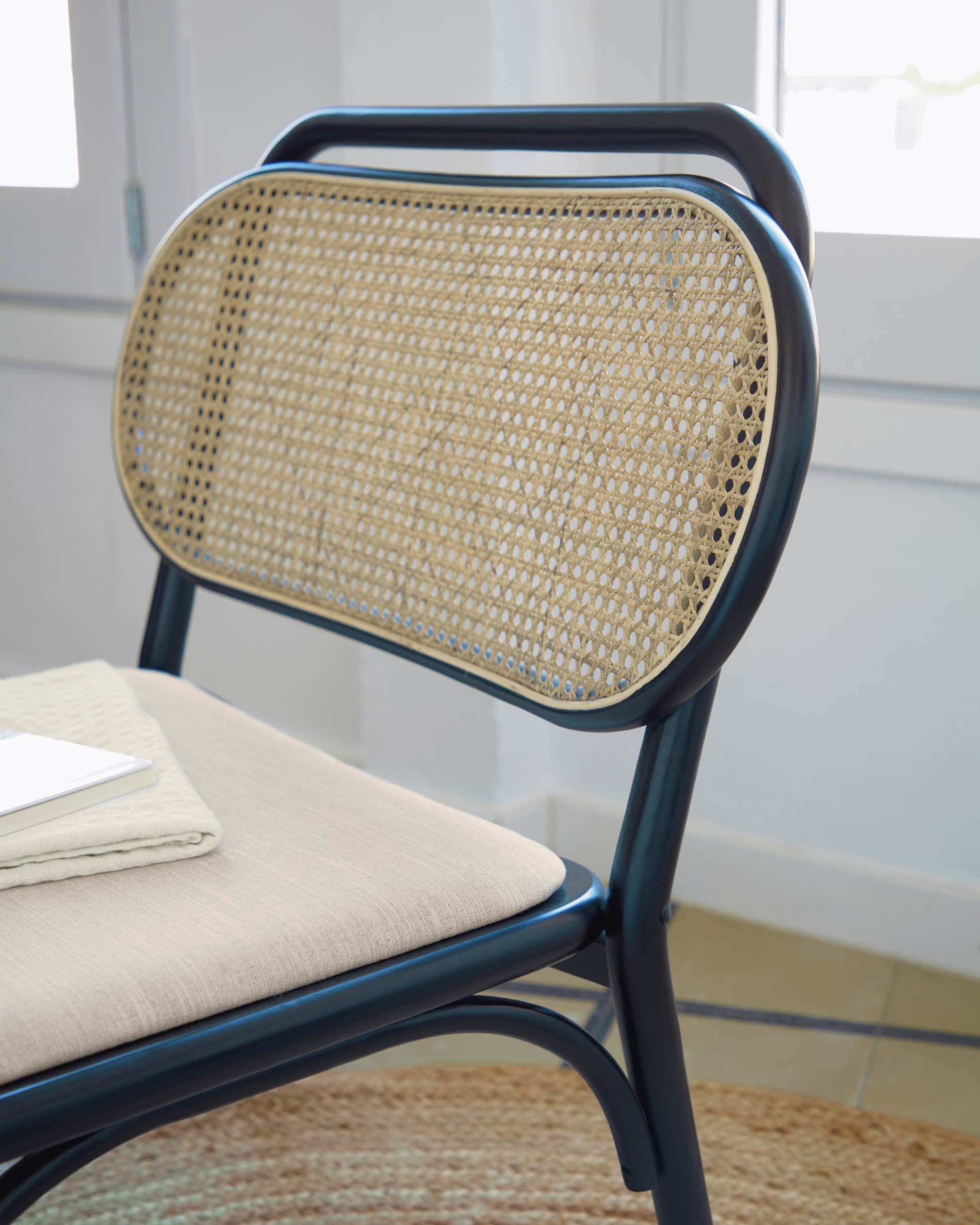 Stilvoller Doriane Sessel aus massiver Ulme mit schwarzem Finish und gepolstertem Sitz, perfekt für moderne Wohnräume.