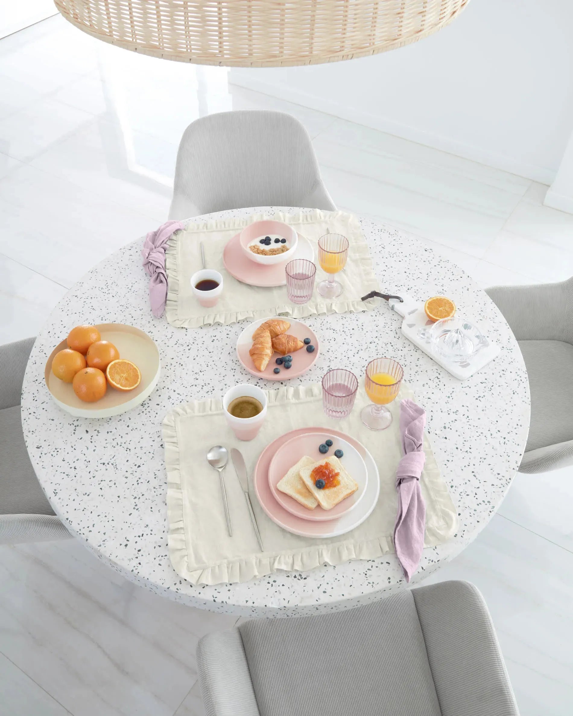 Moderner runder Tisch mit weißer Terrazzo-Platte und Akazienholzgestell, Ø 120 cm, ideal für stilvolle Essbereiche, von Kave Home.