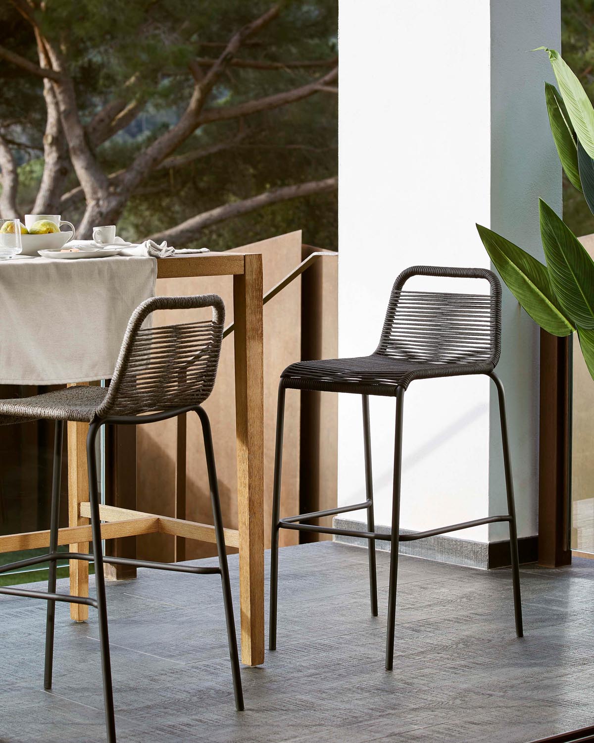 Eleganter Hocker aus schwarzem Seil und Stahl, ideal für draussen.