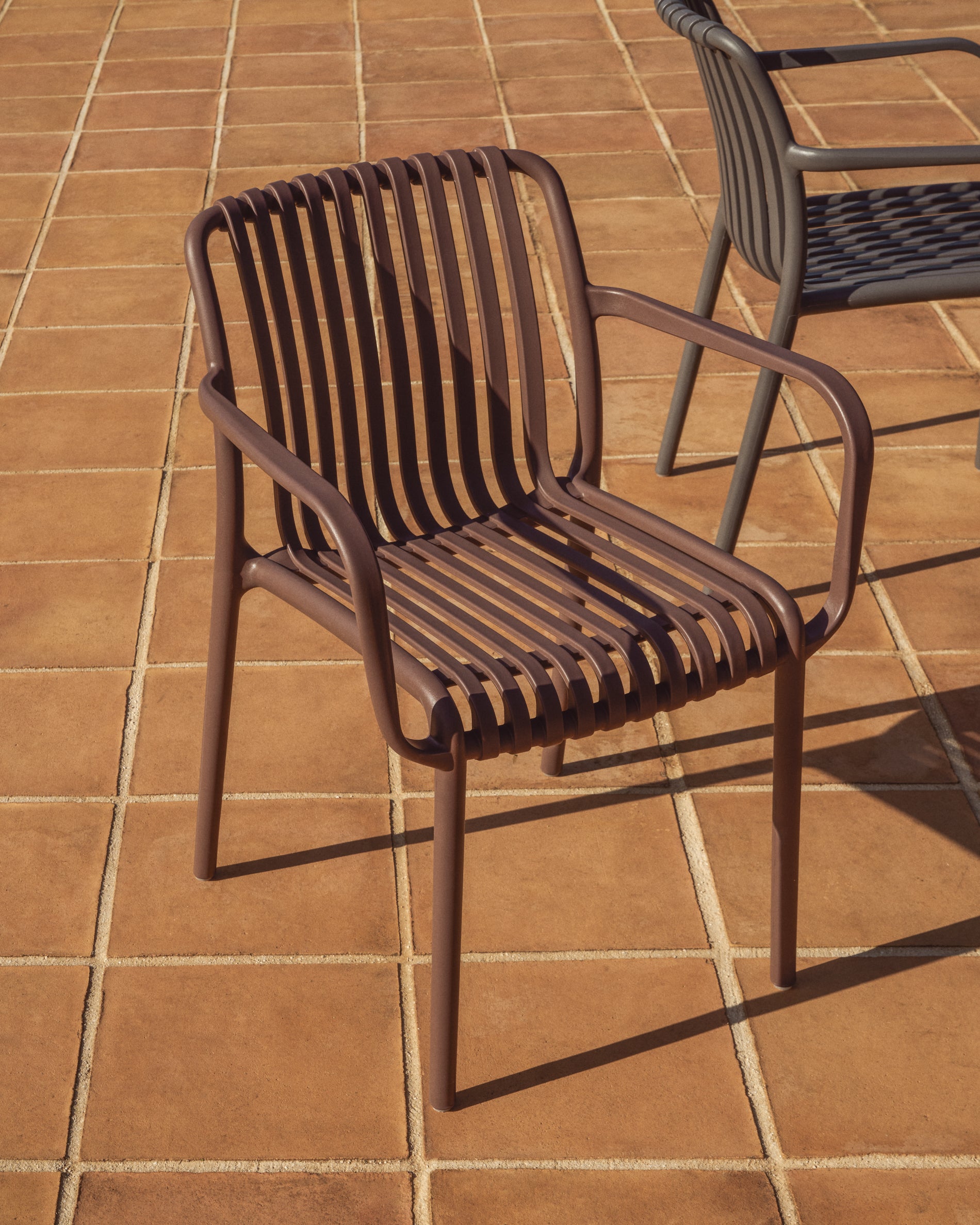 Eleganter stapelbarer Gartenstuhl Isabellini in warmem Braun, ideal für entspannte Stunden im Freien, von Kave Home.