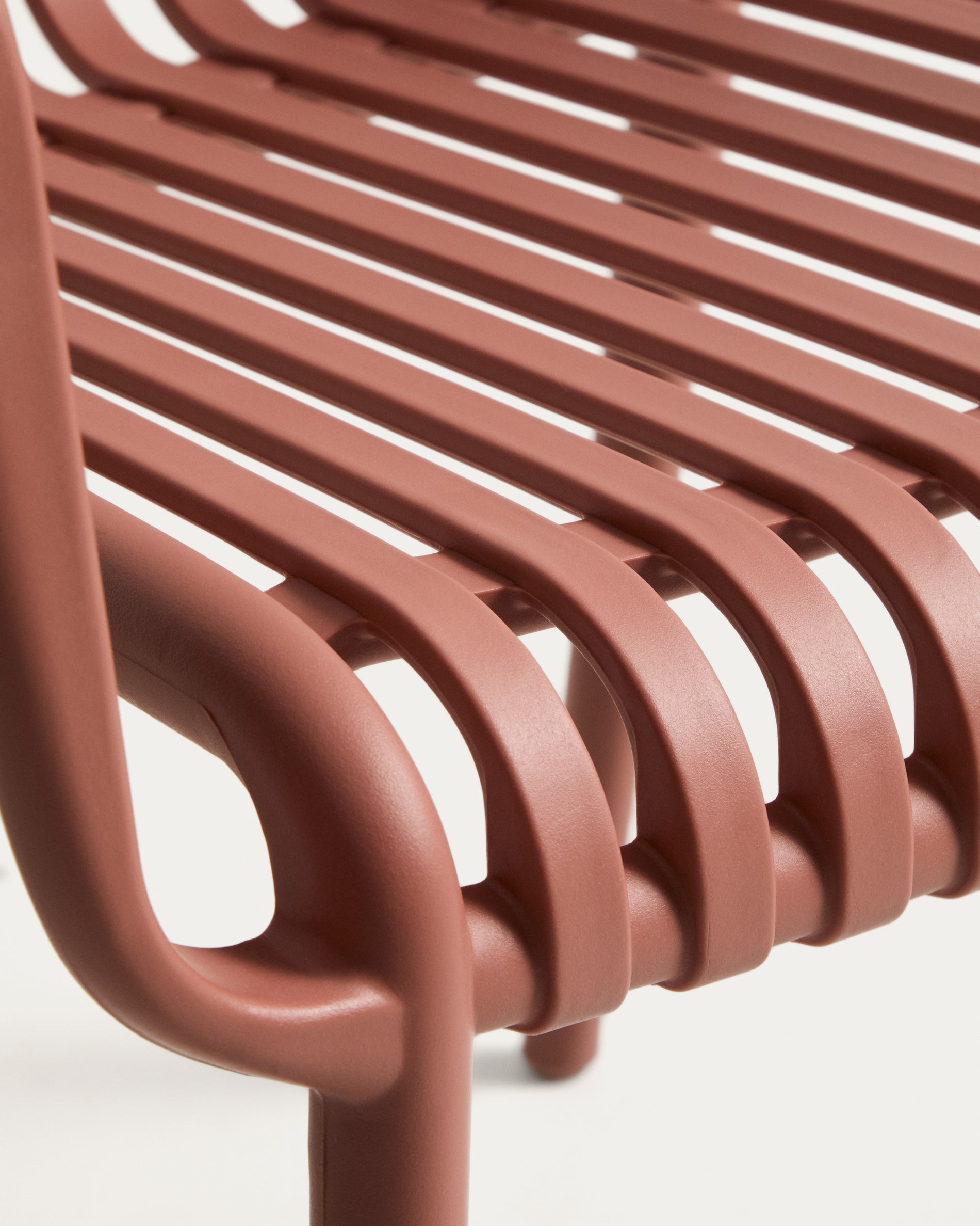 Eleganter stapelbarer Gartenstuhl Isabellini in warmem Terrakotta, ideal für gemütliche Stunden im Freien und moderne Terrassengestaltung.
