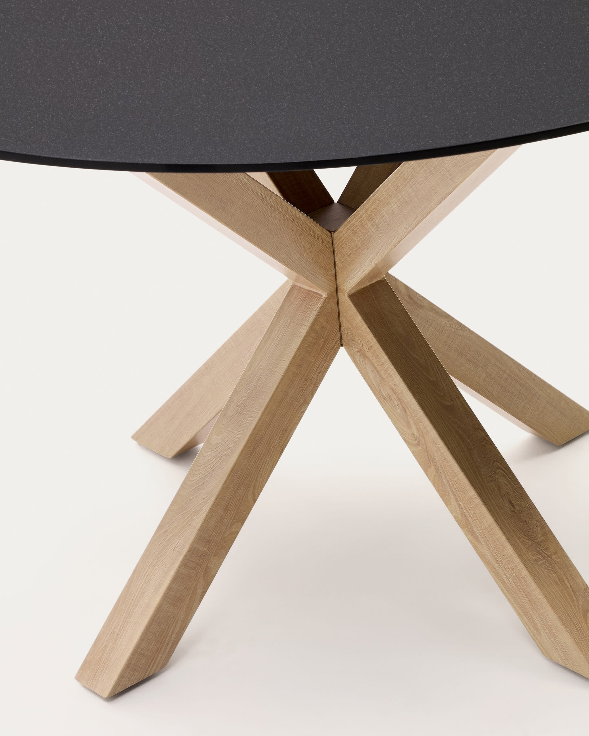 Eleganter Tisch Argo von Kave Home: Schwarze Milchglasplatte und robuste Stahlbeine in Holzoptik, Ø 120 cm – ideal für stilvolle Essbereiche.