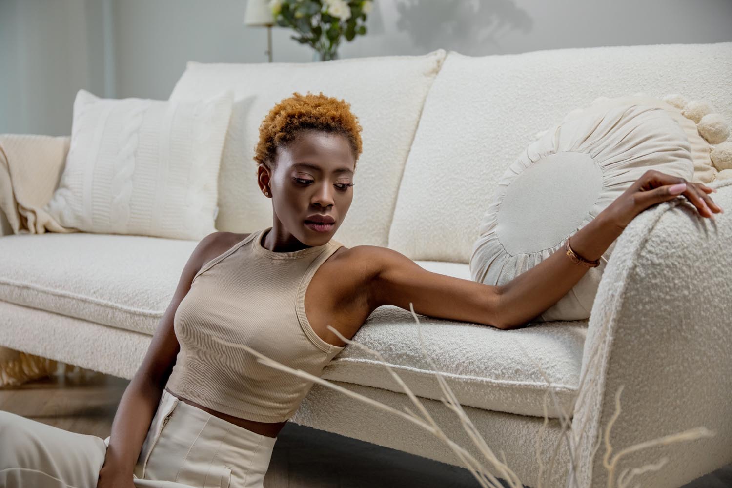 Stilvolles 2-Sitzer Boucle-Sofa in sanften Beige- und Schwarztönen, perfekt für zeitgemäße Wohnkonzepte von Cosmopolitan Design.