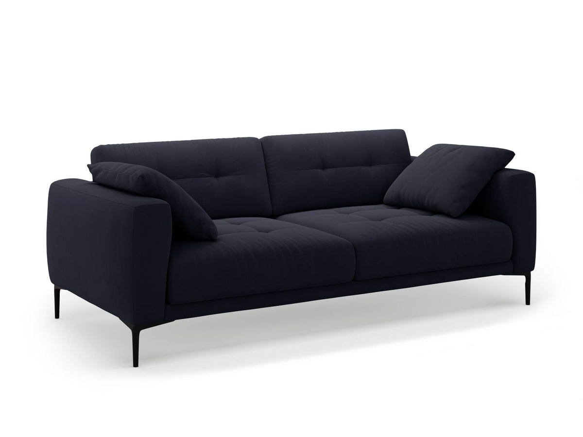 Beige Samt-Sofa Lazio mit 4 Sitzplätzen, Massivholzrahmen, Sitzpolster und schwarzen Metallbeinen, Frontalansicht im Wohnraum.
