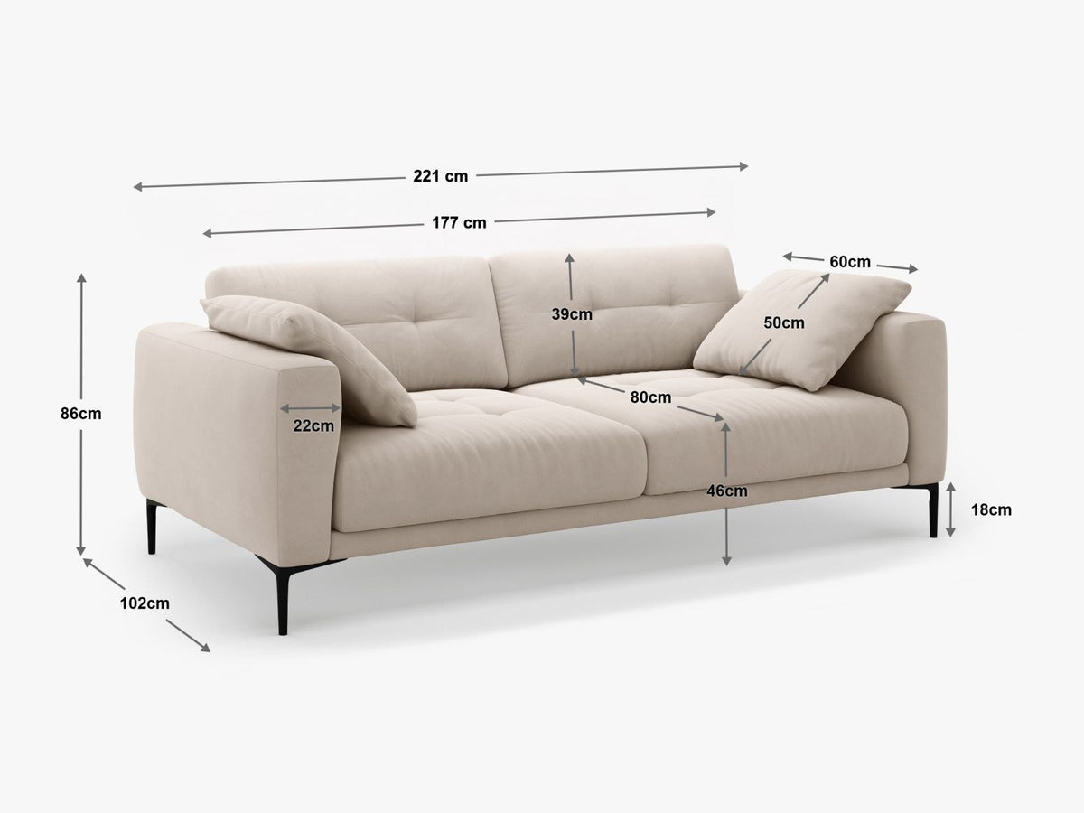 Beige Samt-Sofa Lazio mit 4 Sitzplätzen, Massivholzrahmen, Sitzpolster und schwarzen Metallbeinen, Frontalansicht im Wohnraum.